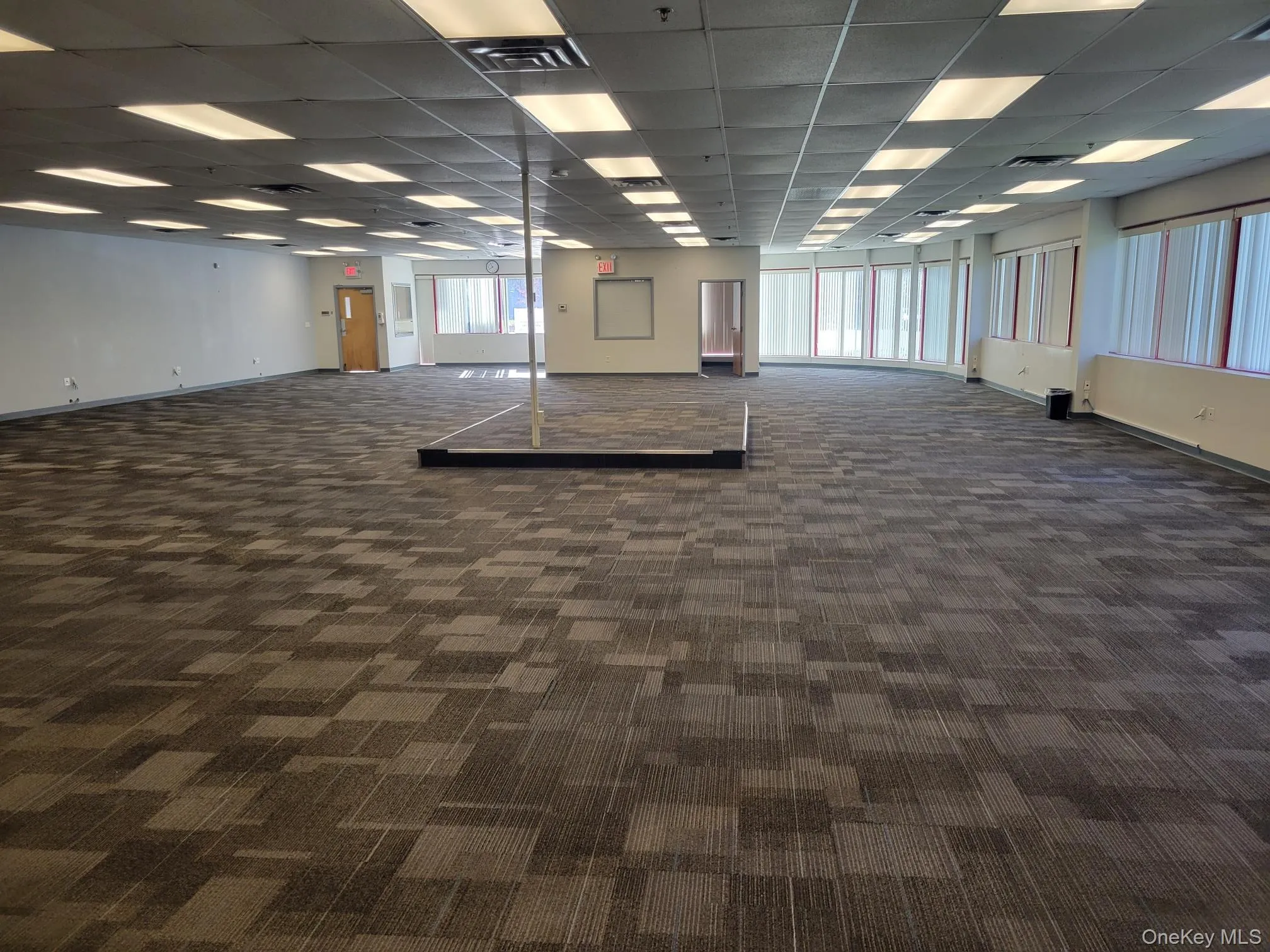 Unfurnished room with dark carpet and a paneled ceiling Unfurnished room with dark carpet and a paneled ceiling