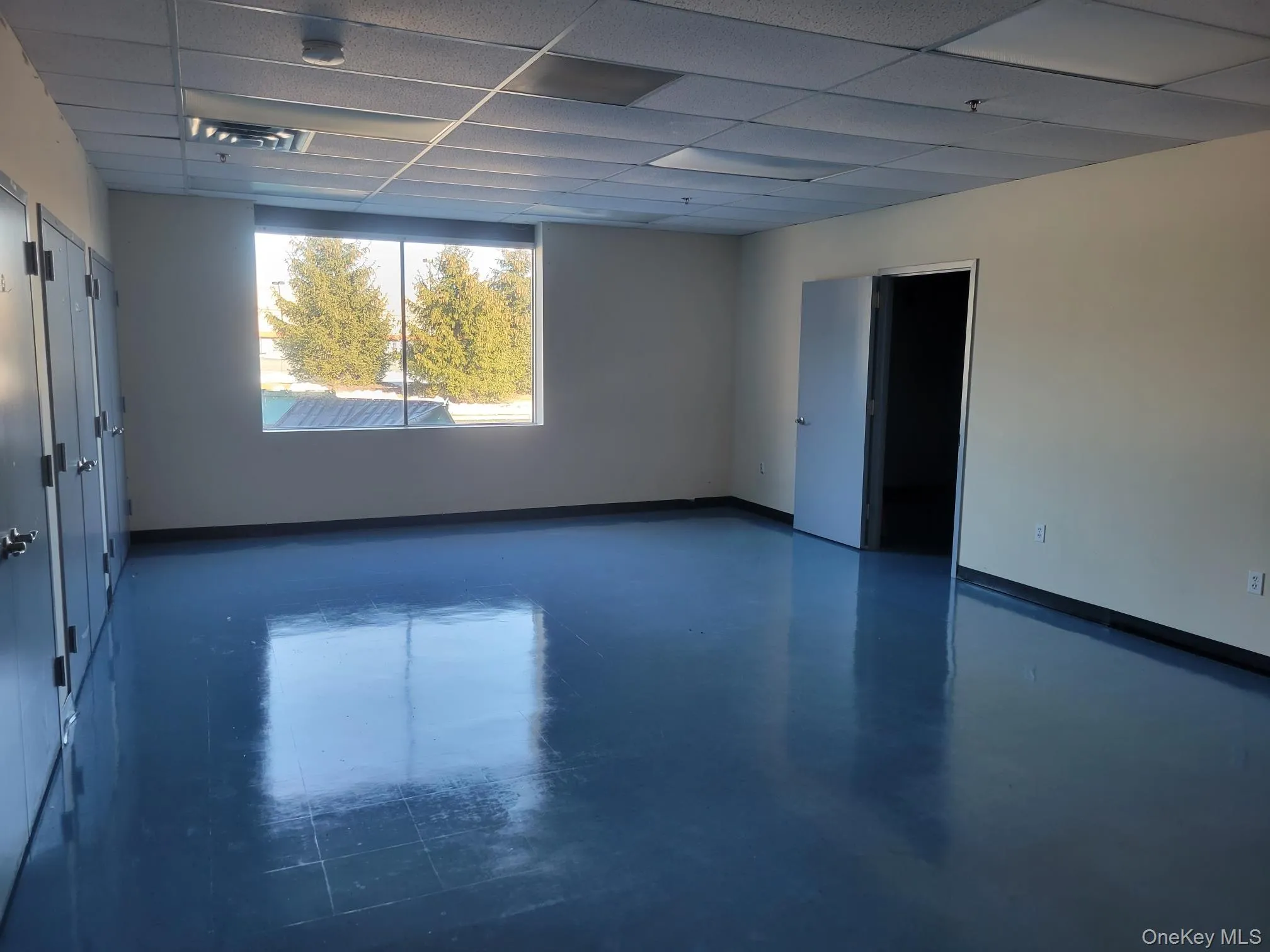 Empty room featuring a drop ceiling and concrete flooring Empty room featuring a drop ceiling and concrete flooring