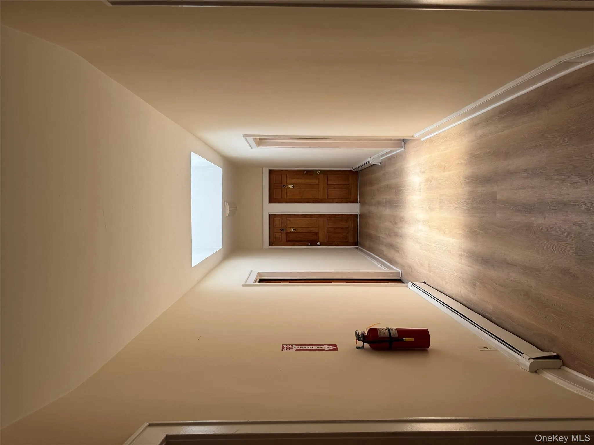 Hall with wood finished floors, a baseboard radiator, and a skylight Hall with wood finished floors, a baseboard radiator, and a skylight