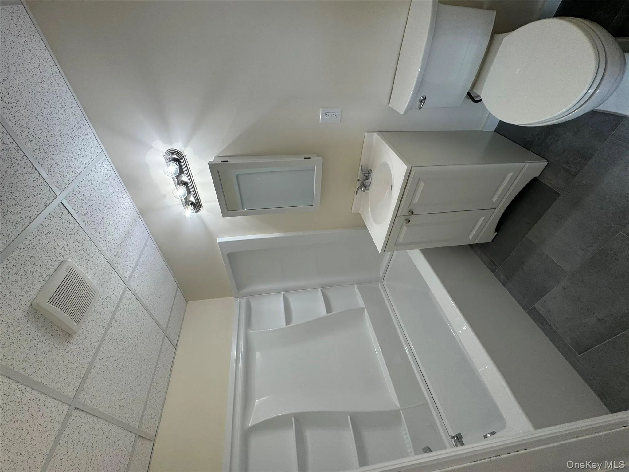 Full bath featuring vanity, shower combination, and a drop ceiling Full bath featuring vanity, shower combination, and a drop ceiling