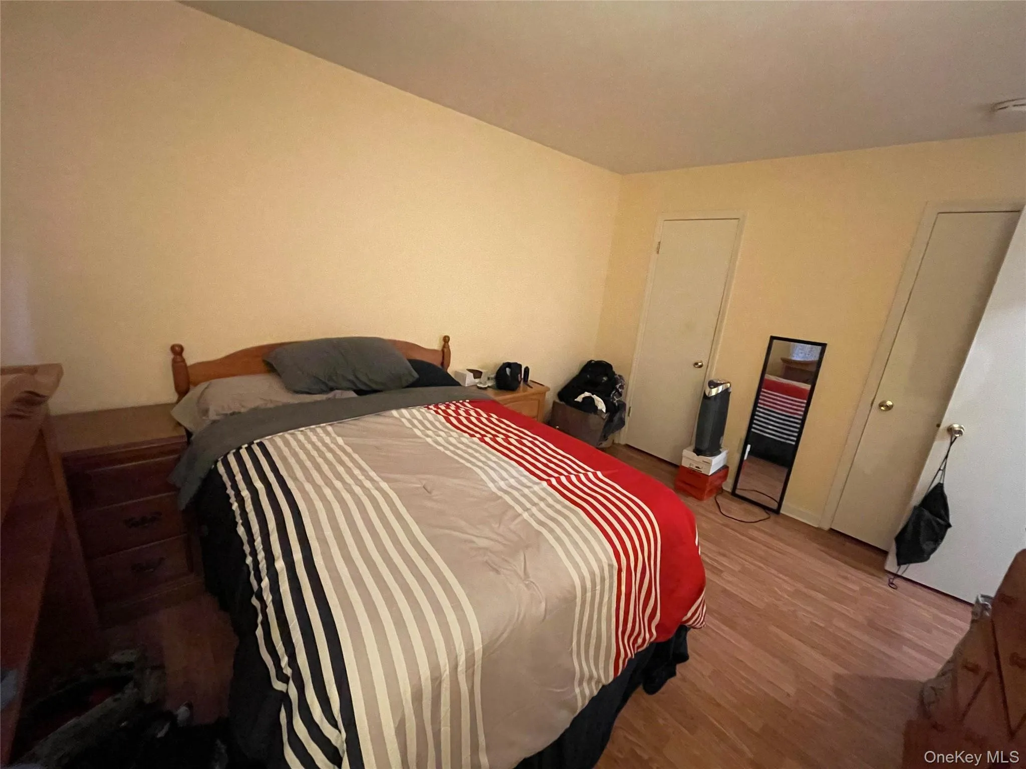 Bedroom featuring wood finished floors and a closet Bedroom featuring wood finished floors and a closet