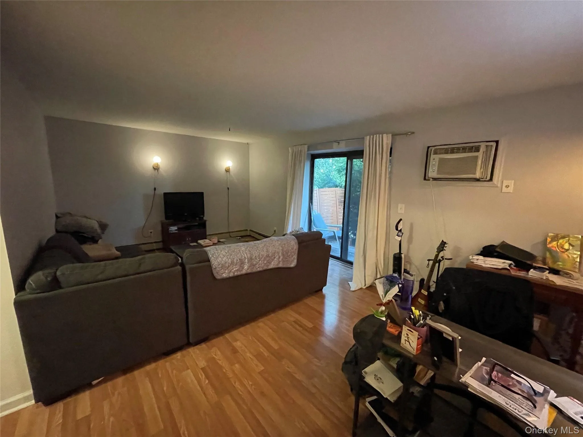 Living area with wood finished floors and a wall unit AC Living area with wood finished floors and a wall unit AC