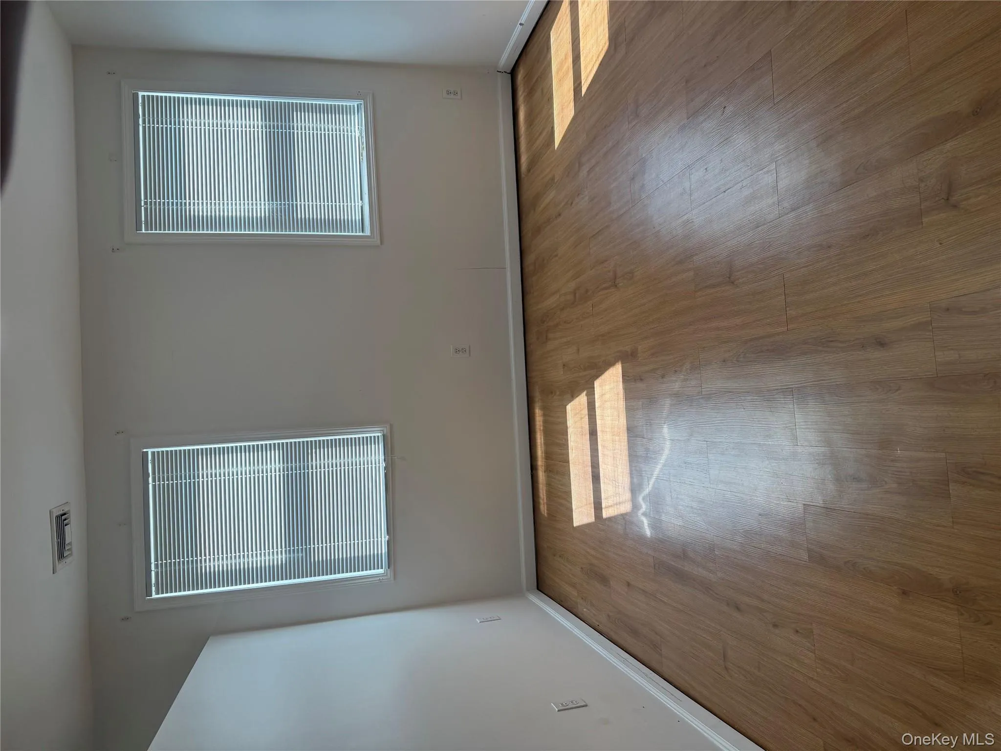 Empty room featuring wood finished floors and baseboards Empty room featuring wood finished floors and baseboards