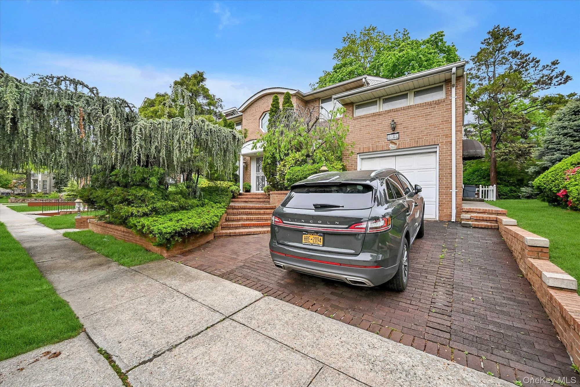 View of front facade with driveway, brick siding, and a garage View of front facade with driveway, brick siding, and a garage