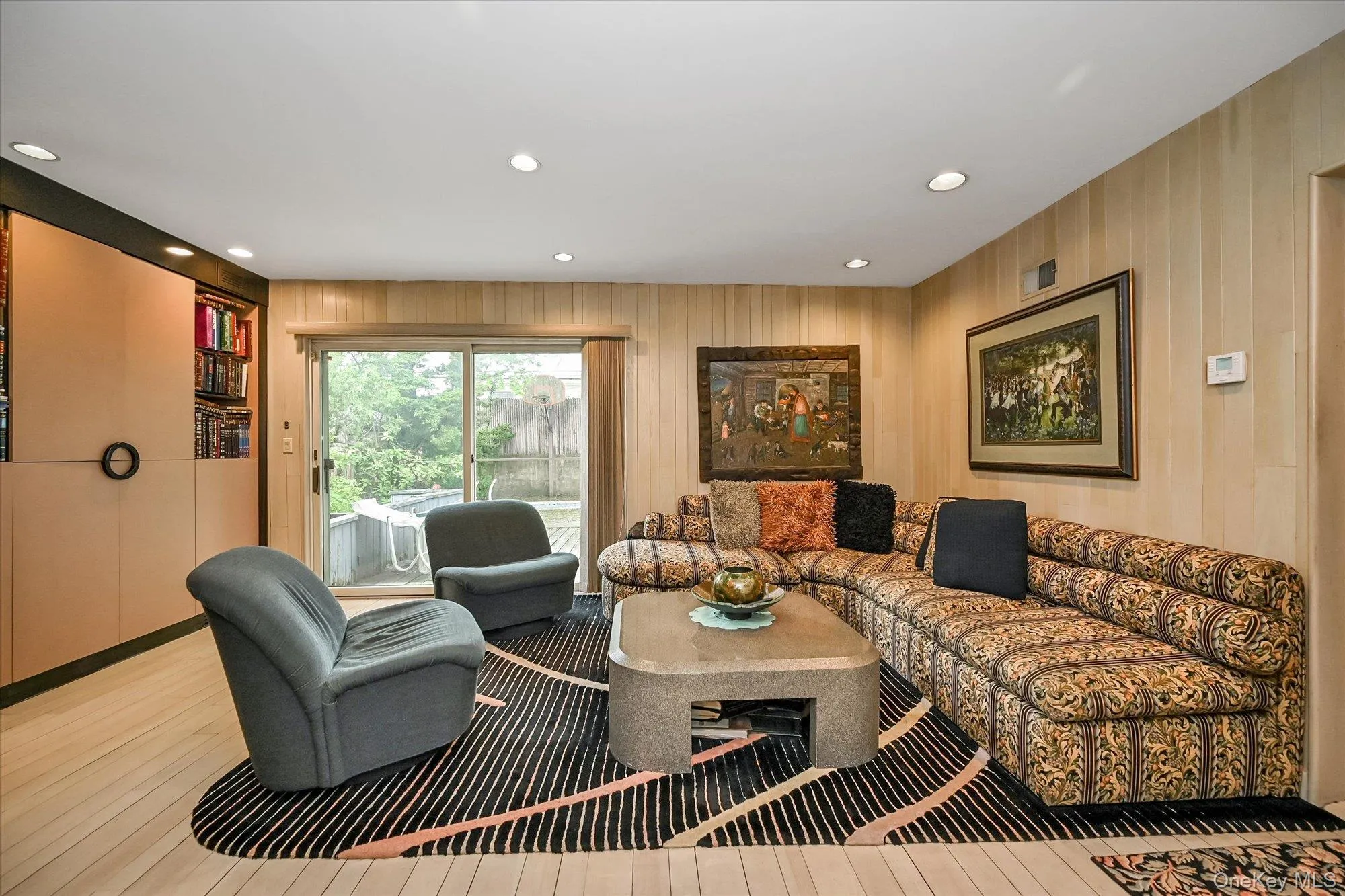 Living room featuring recessed lighting, wood finished floors, and wooden walls Living room featuring recessed lighting, wood finished floors, and wooden walls