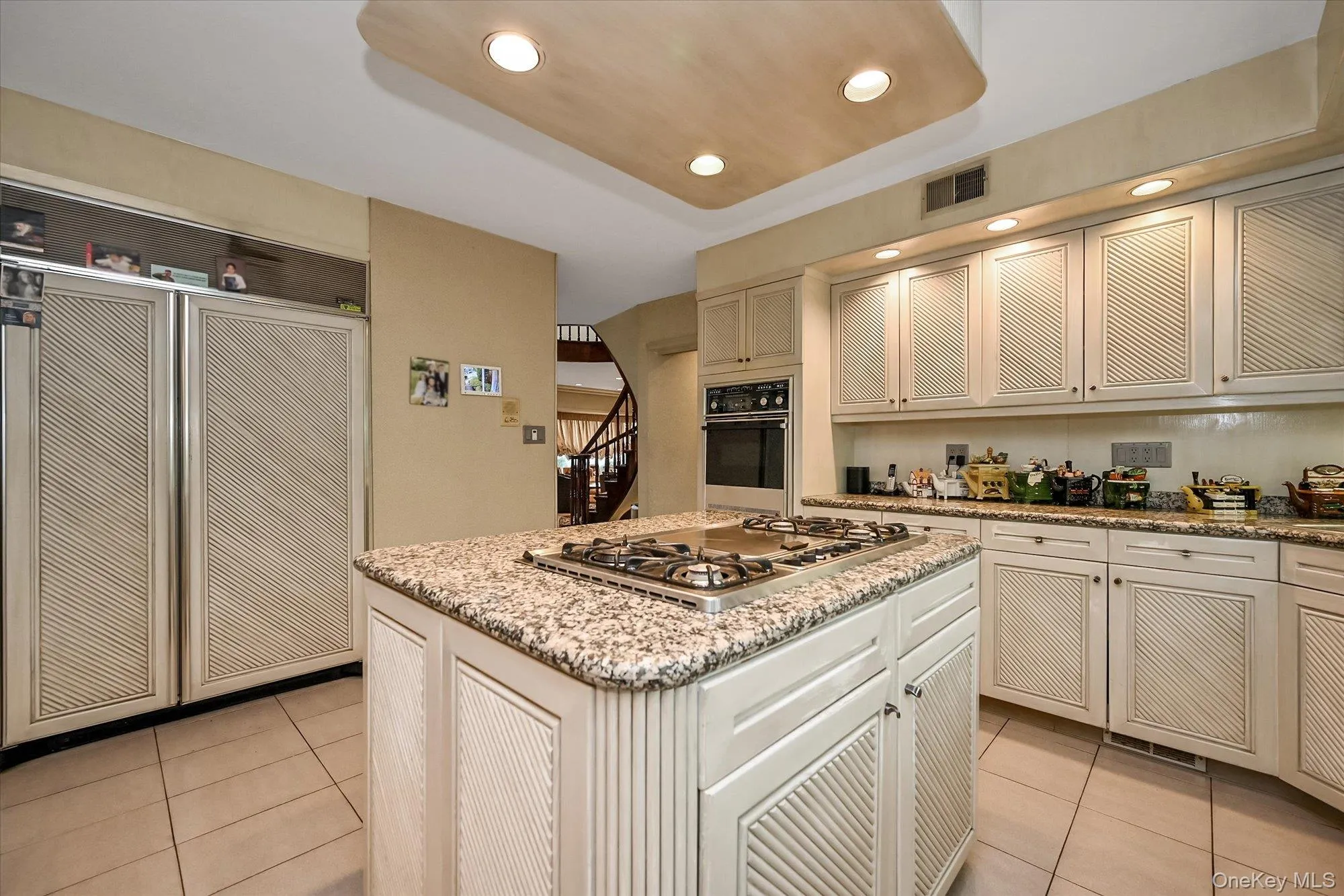 Kitchen with light stone counters, light tile patterned floors, a kitchen island, recessed lighting, and oven Kitchen with light stone counters, light tile patterned floors, a kitchen island, recessed lighting, and oven