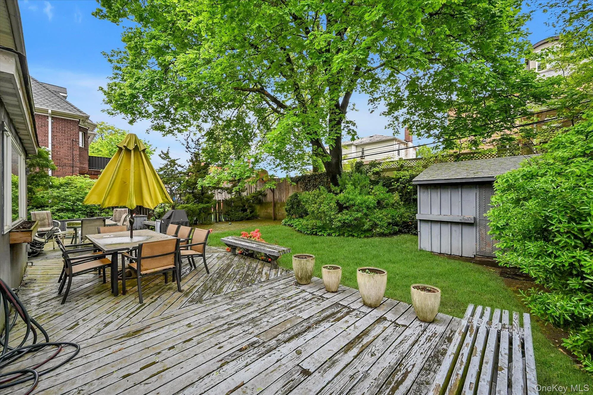 Deck featuring outdoor dining space, a storage shed, and a fenced backyard Deck featuring outdoor dining space, a storage shed, and a fenced backyard