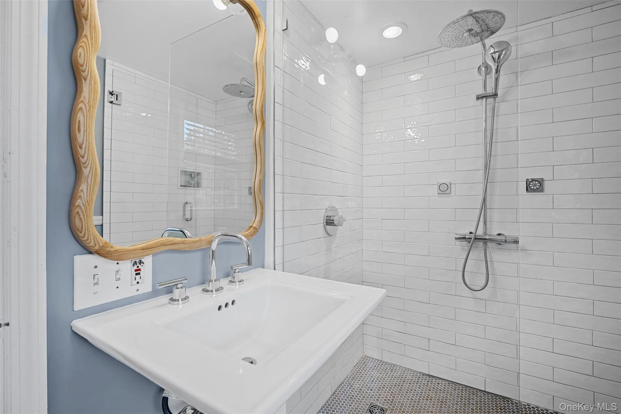 Bathroom featuring tiled shower and a sink Bathroom featuring tiled shower and a sink
