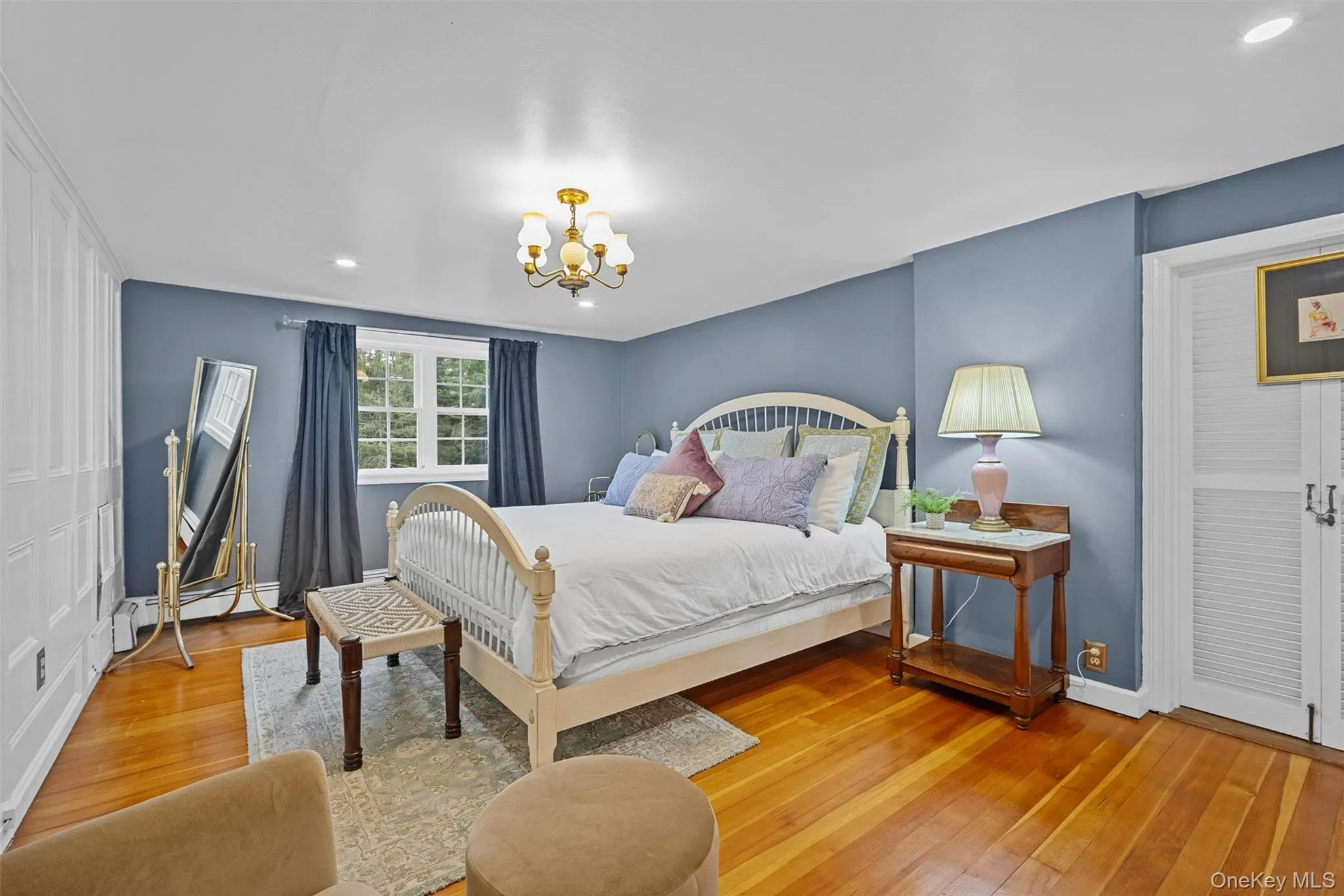 Bedroom with wood finished floors, a chandelier, recessed lighting, and a baseboard heating unit Bedroom with wood finished floors, a chandelier, recessed lighting, and a baseboard heating unit