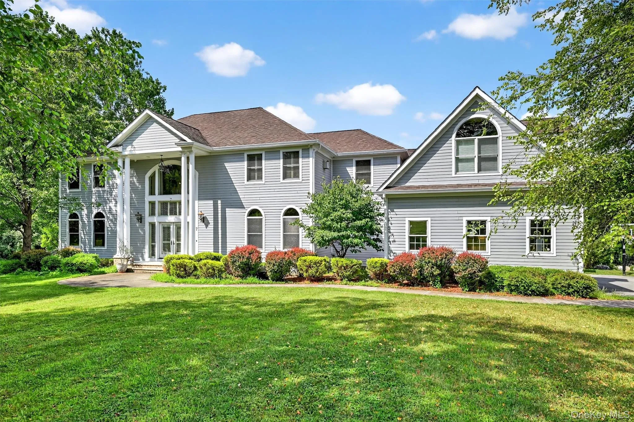 Neoclassical home featuring a front yard Neoclassical home featuring a front yard