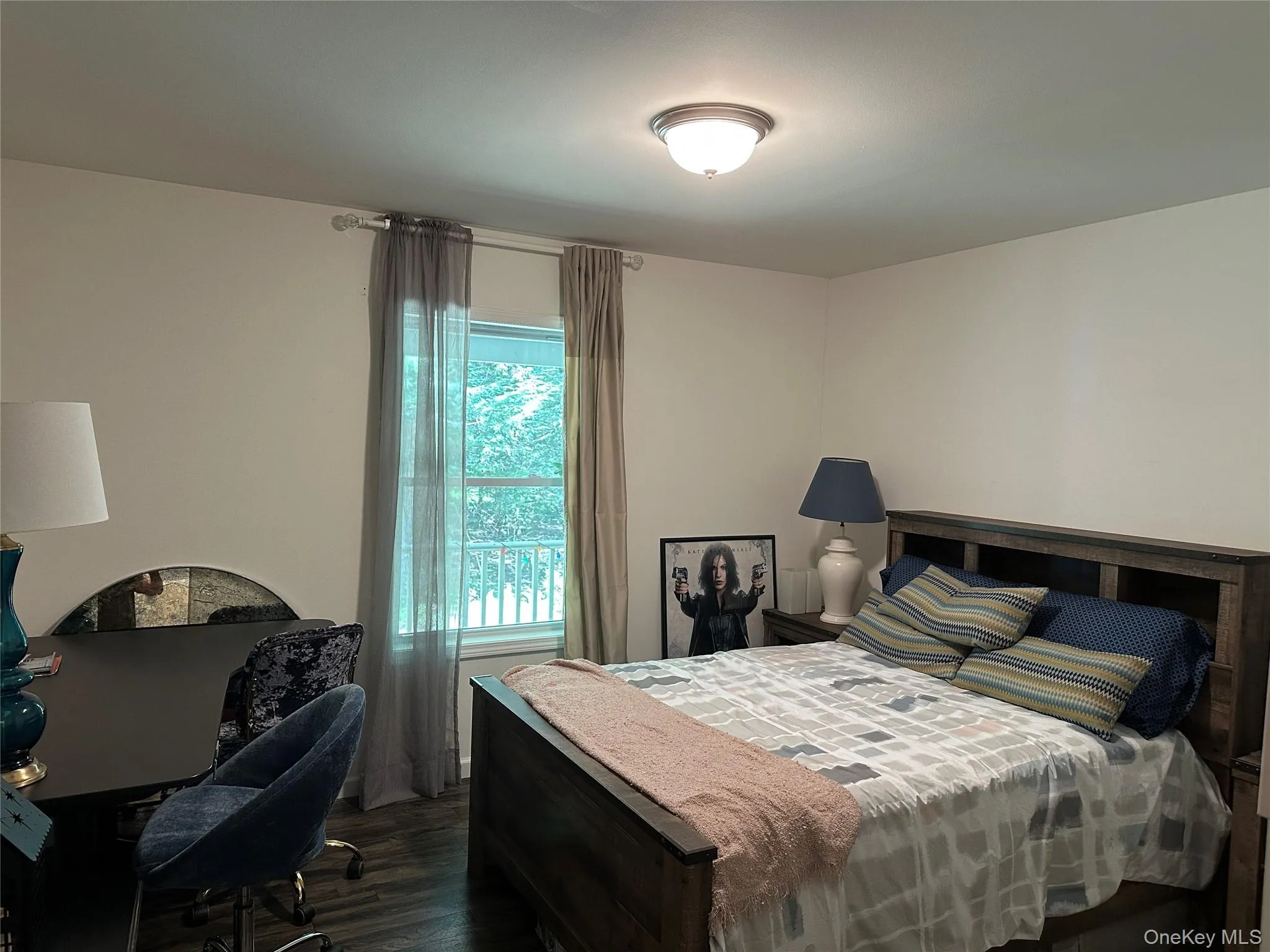 Bedroom with dark wood-type flooring and an office area Bedroom with dark wood-type flooring and an office area