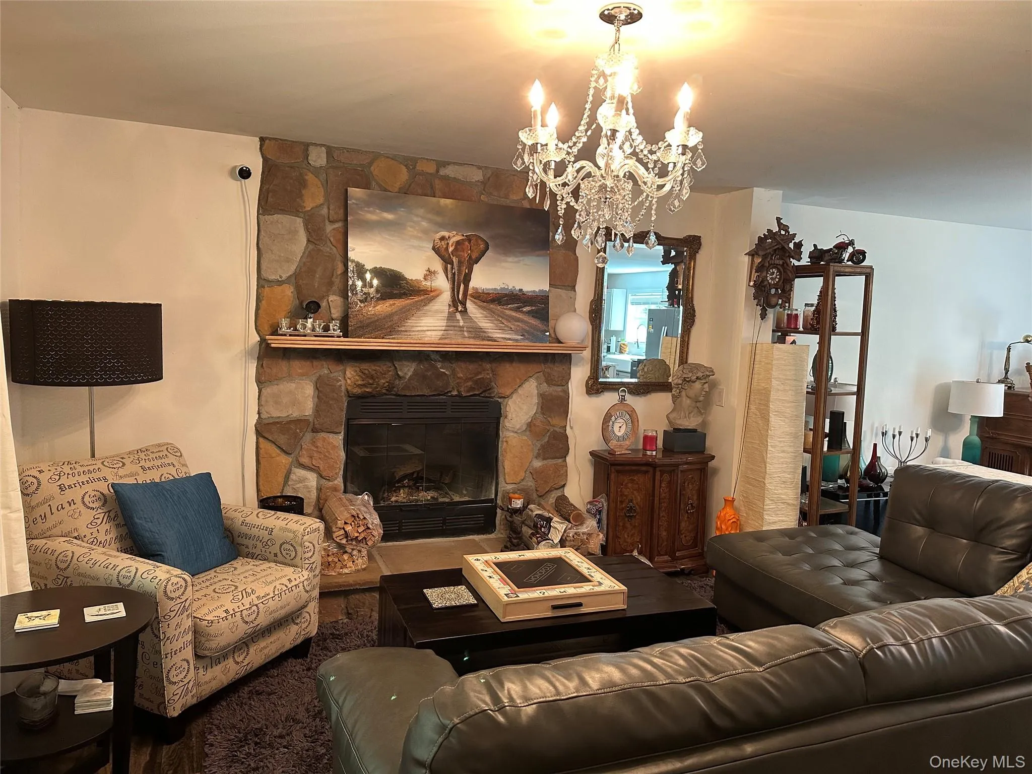 Living room with a stone fireplace and a chandelier Living room with a stone fireplace and a chandelier