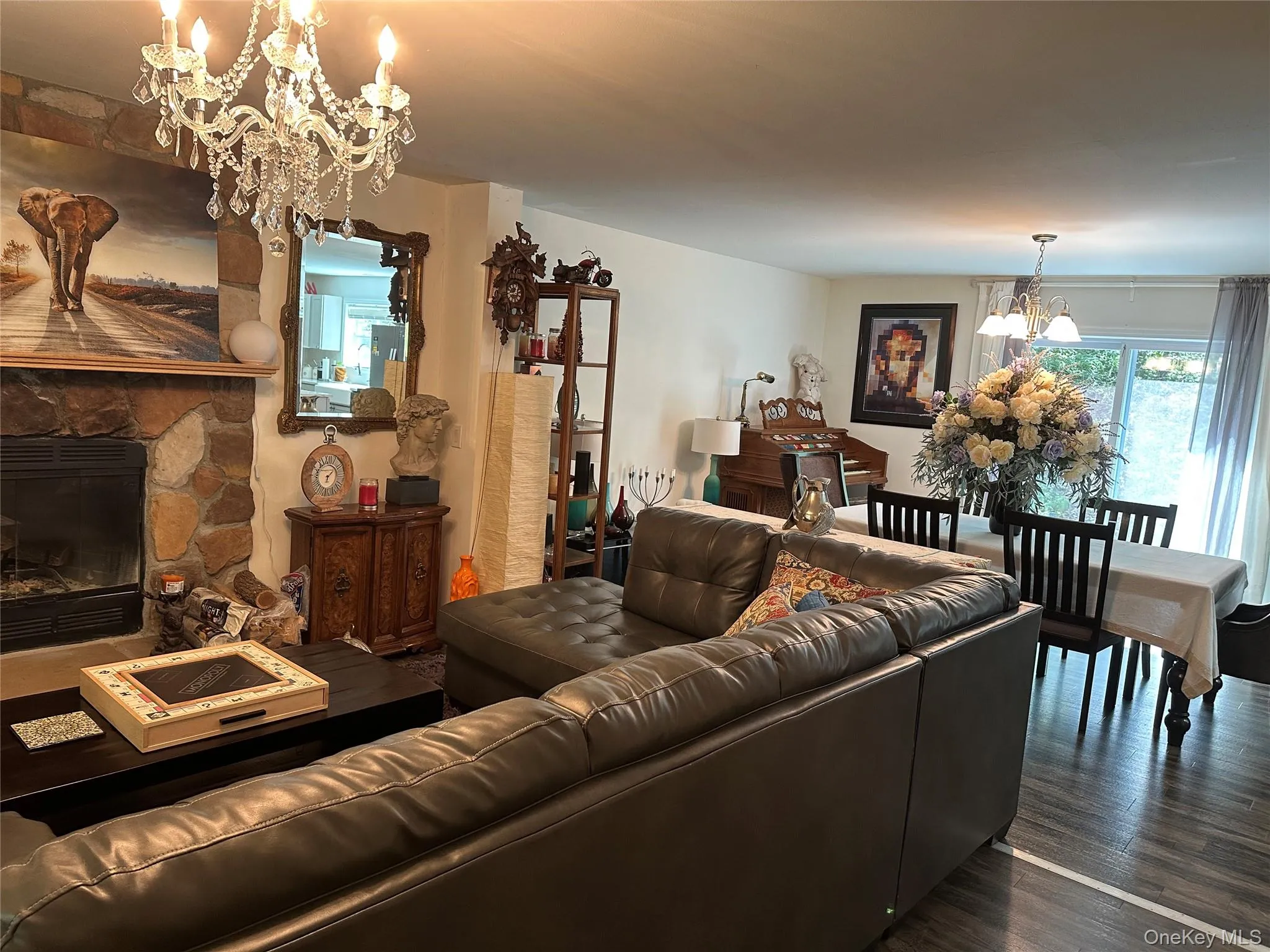 Living room with a chandelier, a fireplace, and wood finished floors Living room with a chandelier, a fireplace, and wood finished floors