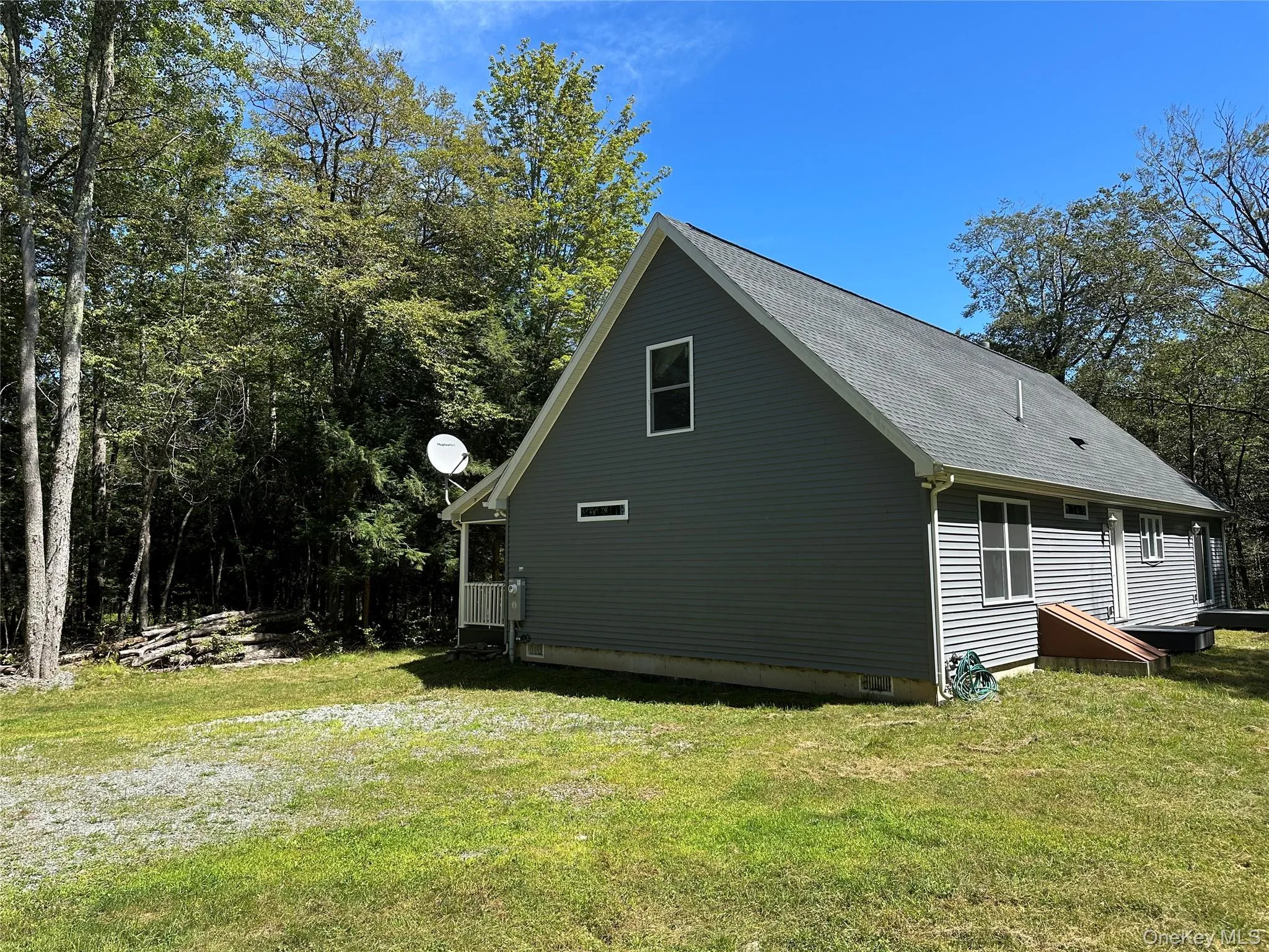 View of side of home with a lawn and a shingled roof View of side of home with a lawn and a shingled roof