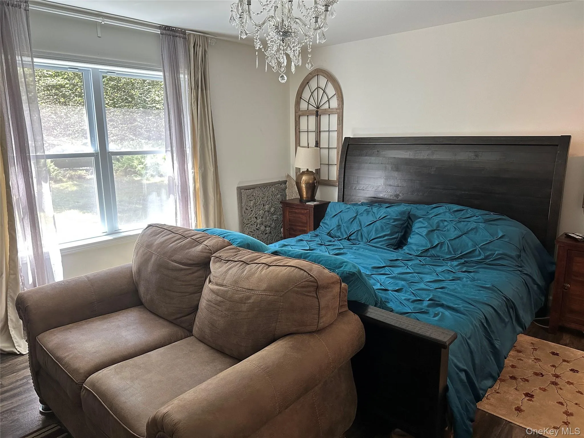 Bedroom featuring wood finished floors and a chandelier Bedroom featuring wood finished floors and a chandelier