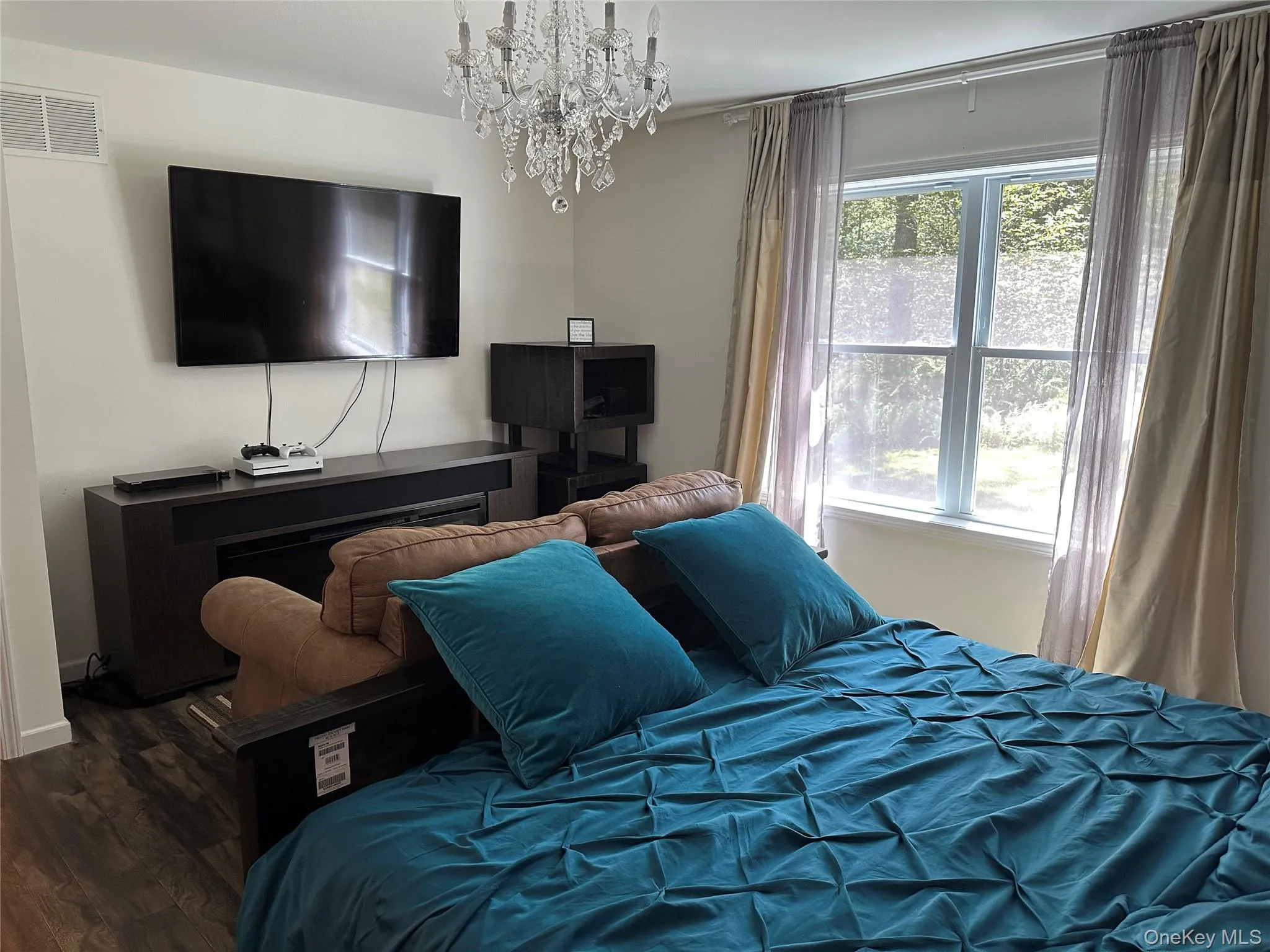 Bedroom with a chandelier and wood finished floors Bedroom with a chandelier and wood finished floors