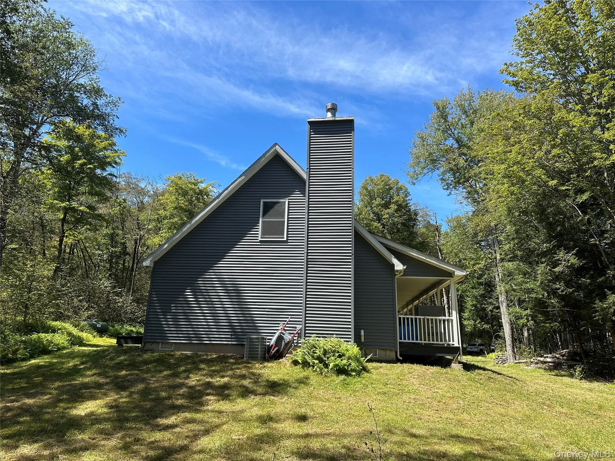 View of home's exterior featuring a chimney and a yard View of home's exterior featuring a chimney and a yard
