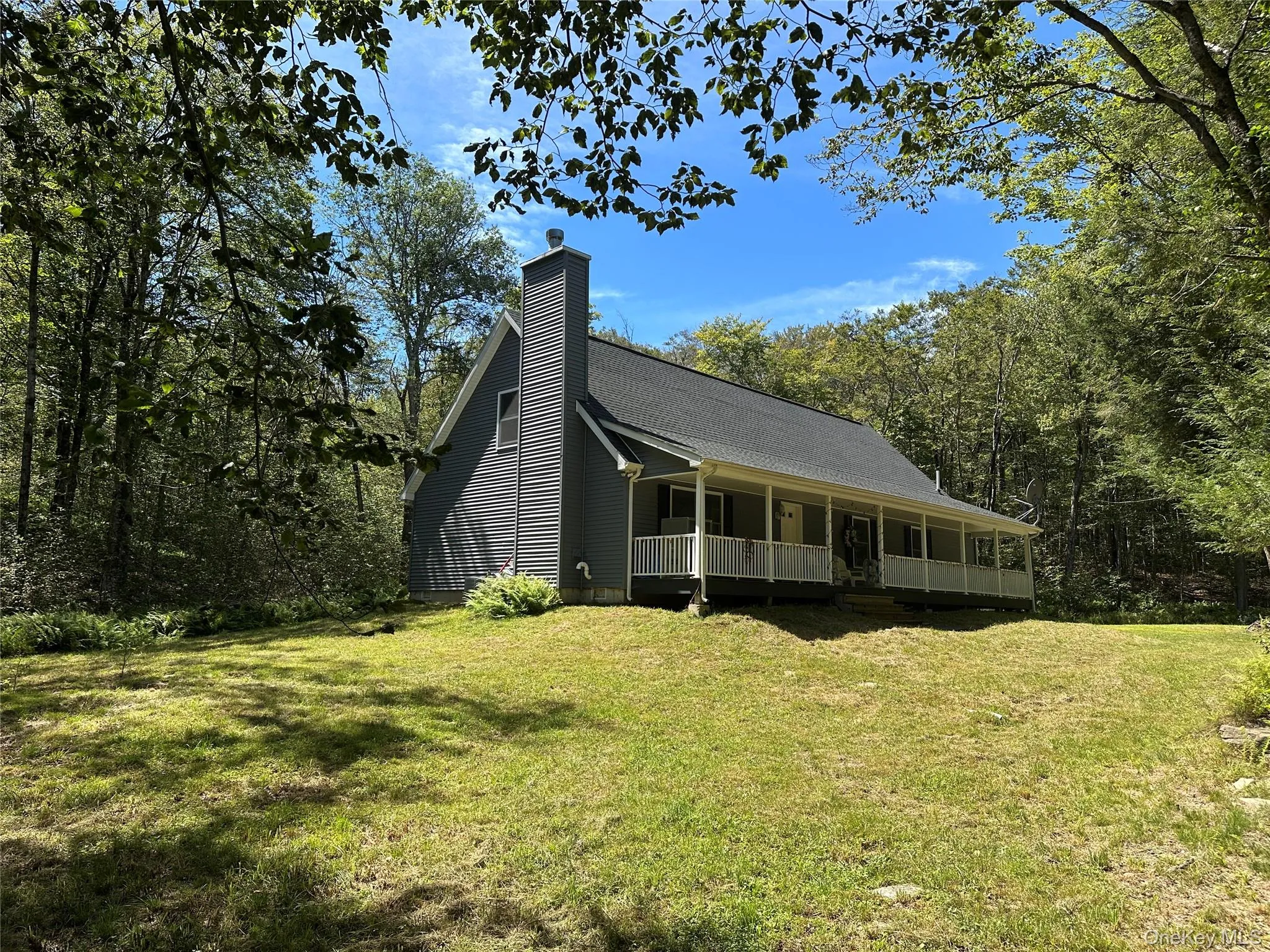 View of front of property with a porch, a front yard, and a chimney View of front of property with a porch, a front yard, and a chimney