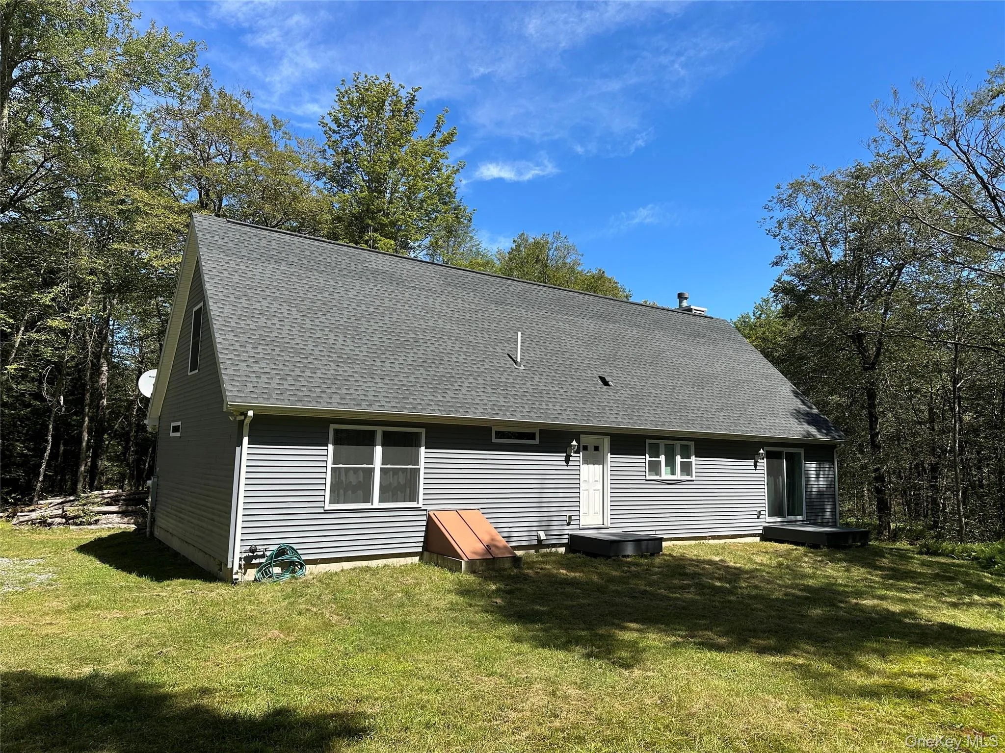 Back of house featuring a lawn and a shingled roof Back of house featuring a lawn and a shingled roof