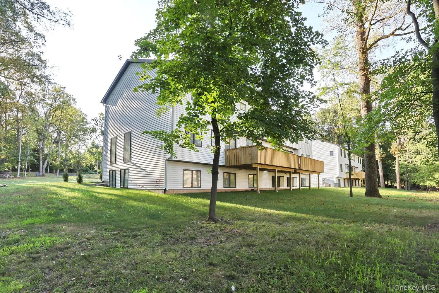 Back of property featuring a yard and a wooden deck Back of property featuring a yard and a wooden deck
