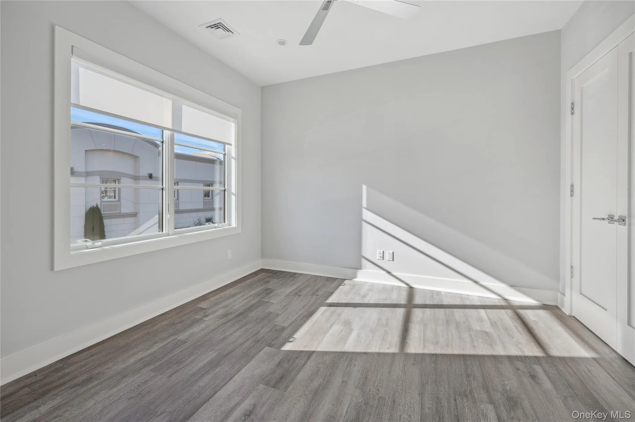 Empty room with wood finished floors and ceiling fan Empty room with wood finished floors and ceiling fan