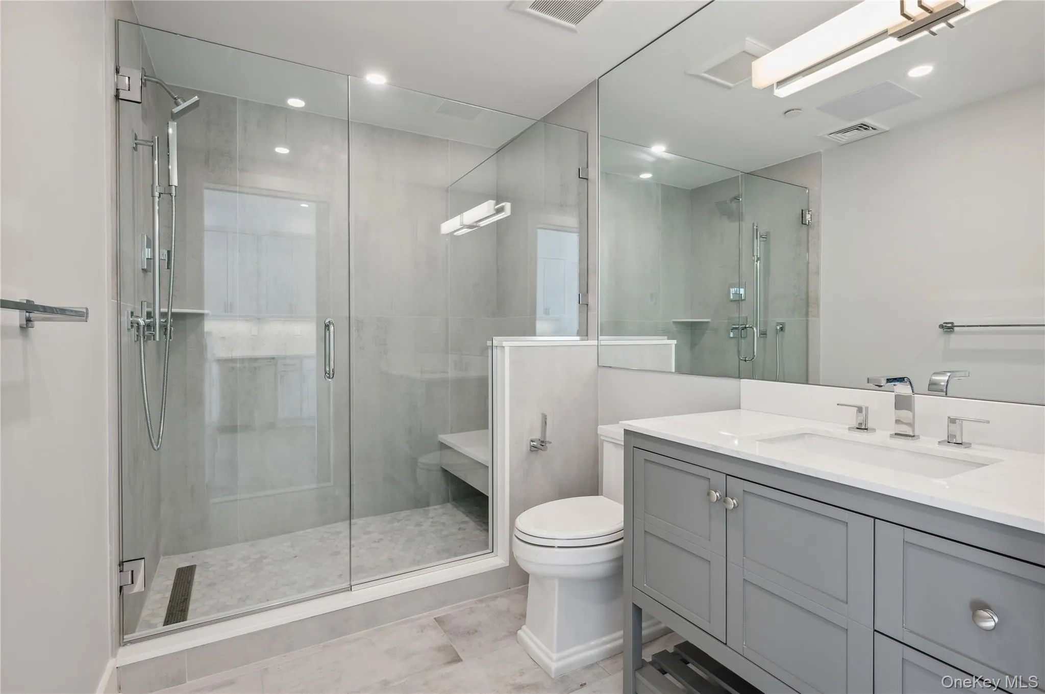 Full bathroom with vanity, a shower stall, and light tile patterned floors Full bathroom with vanity, a shower stall, and light tile patterned floors