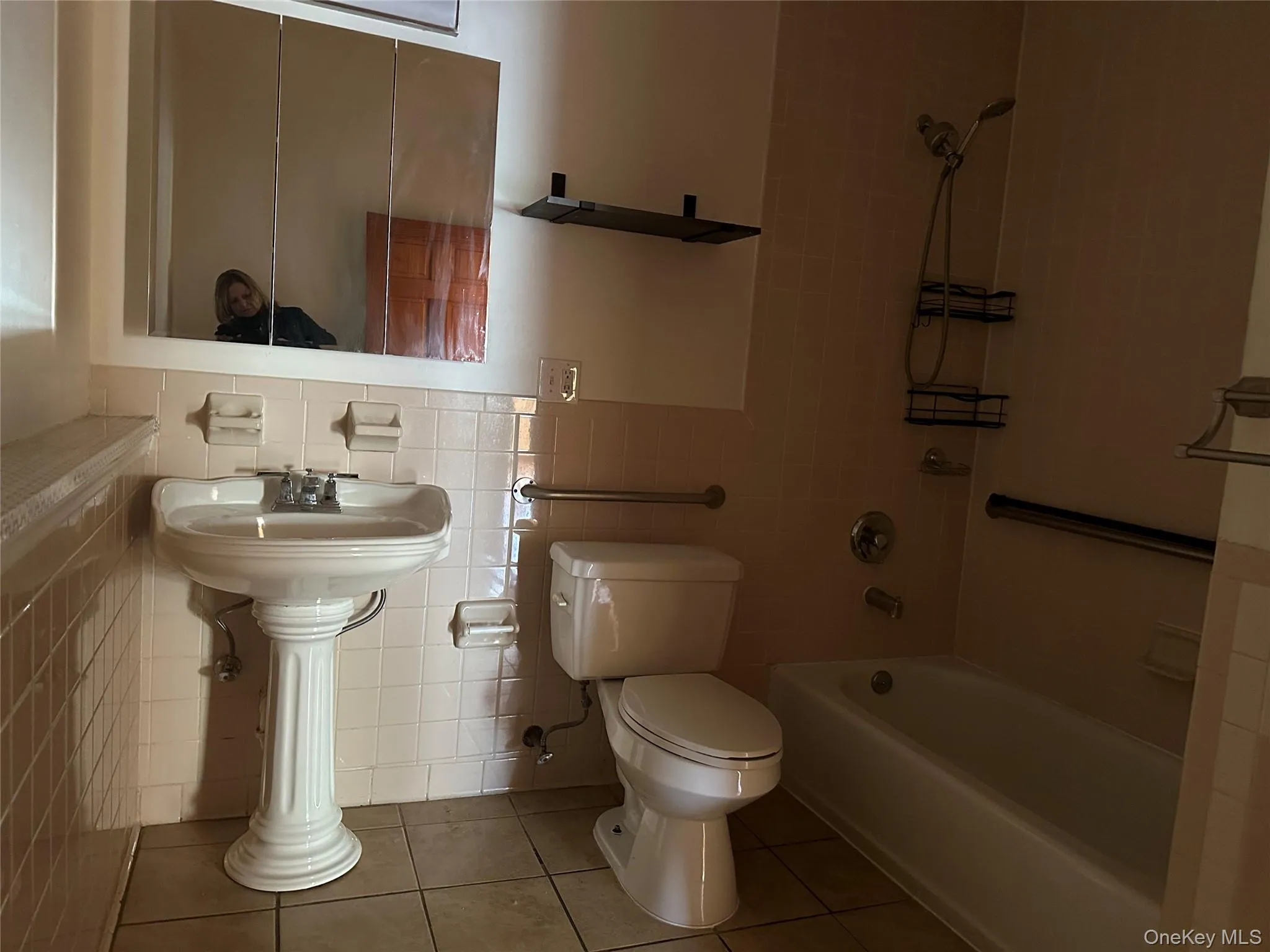 Bathroom with bathtub / shower combination, tile patterned floors, and tile walls Bathroom with bathtub / shower combination, tile patterned floors, and tile walls