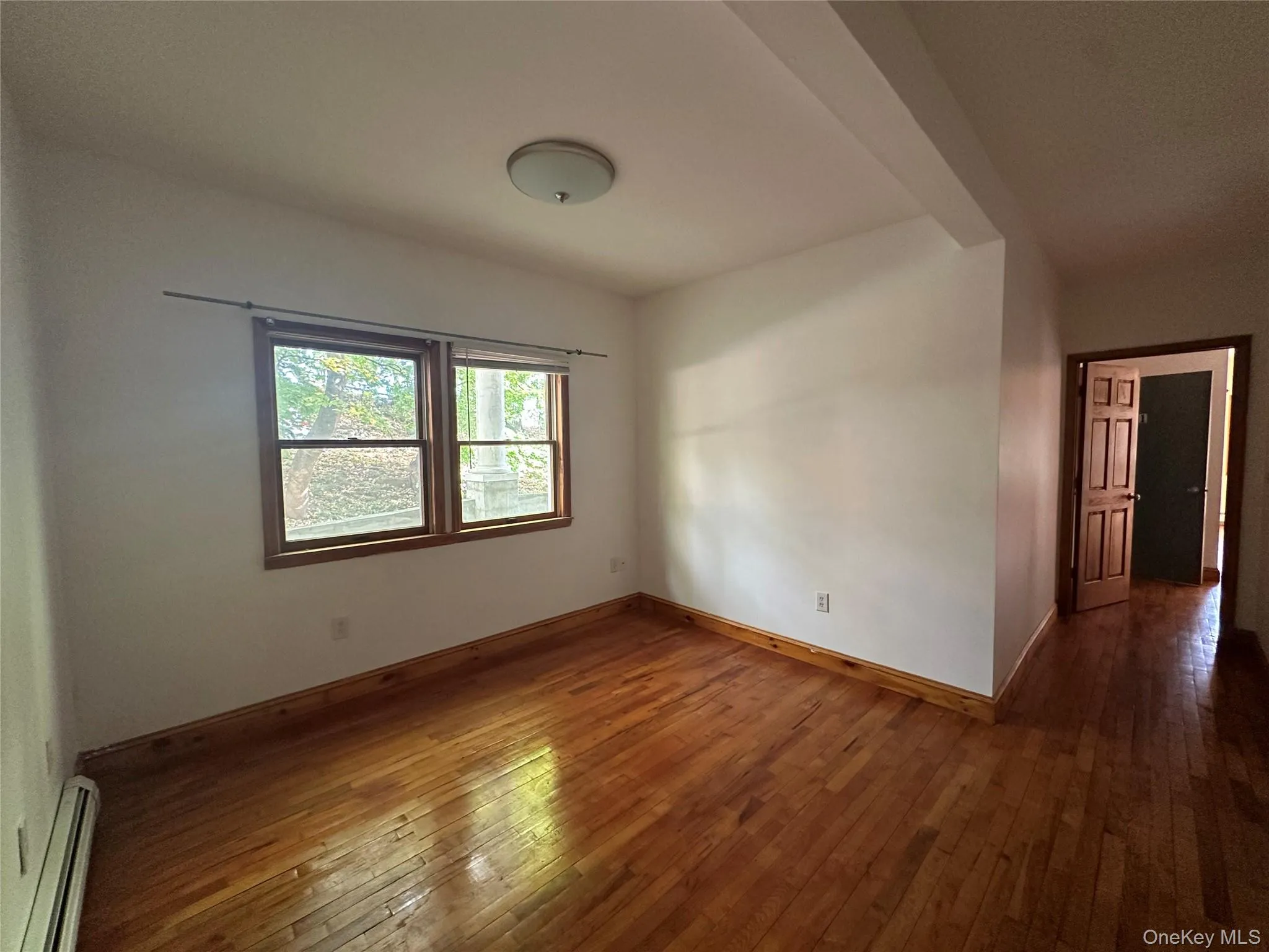 Spare room with a baseboard radiator and hardwood / wood-style flooring Spare room with a baseboard radiator and hardwood / wood-style flooring