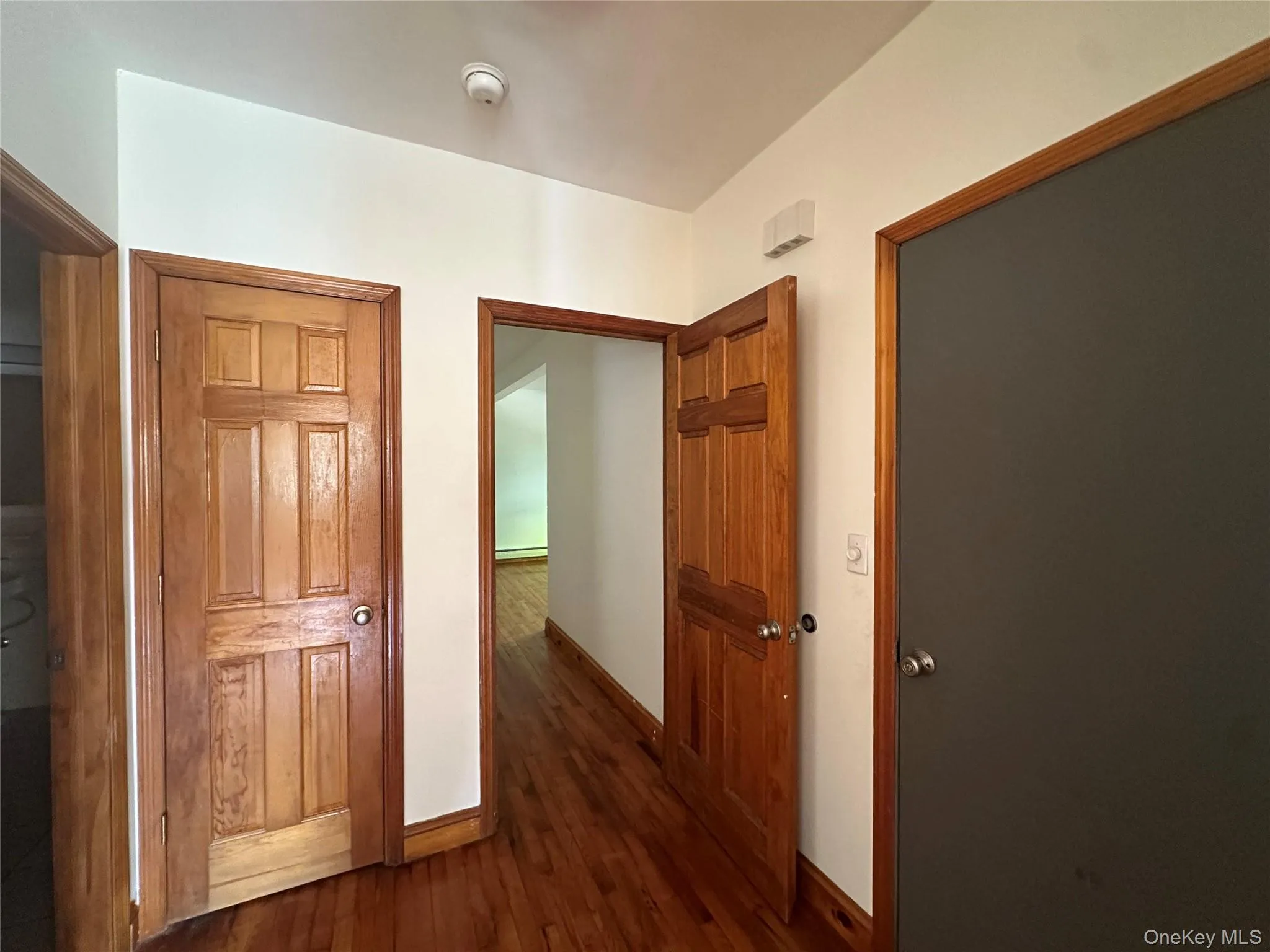 Hallway with baseboards and dark wood-style floors Hallway with baseboards and dark wood-style floors