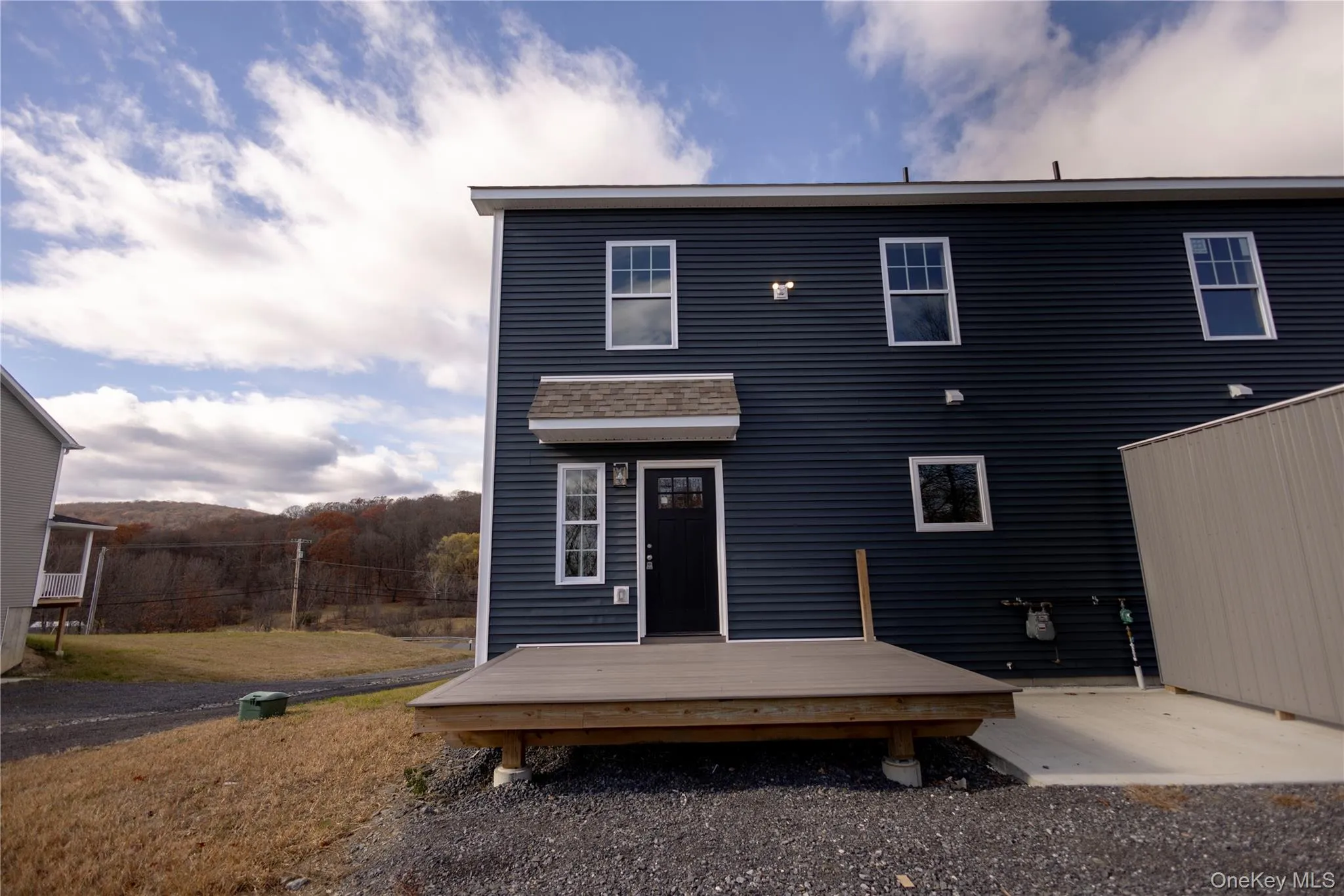 Back of property featuring a wooden deck and a lawn Back of property featuring a wooden deck and a lawn