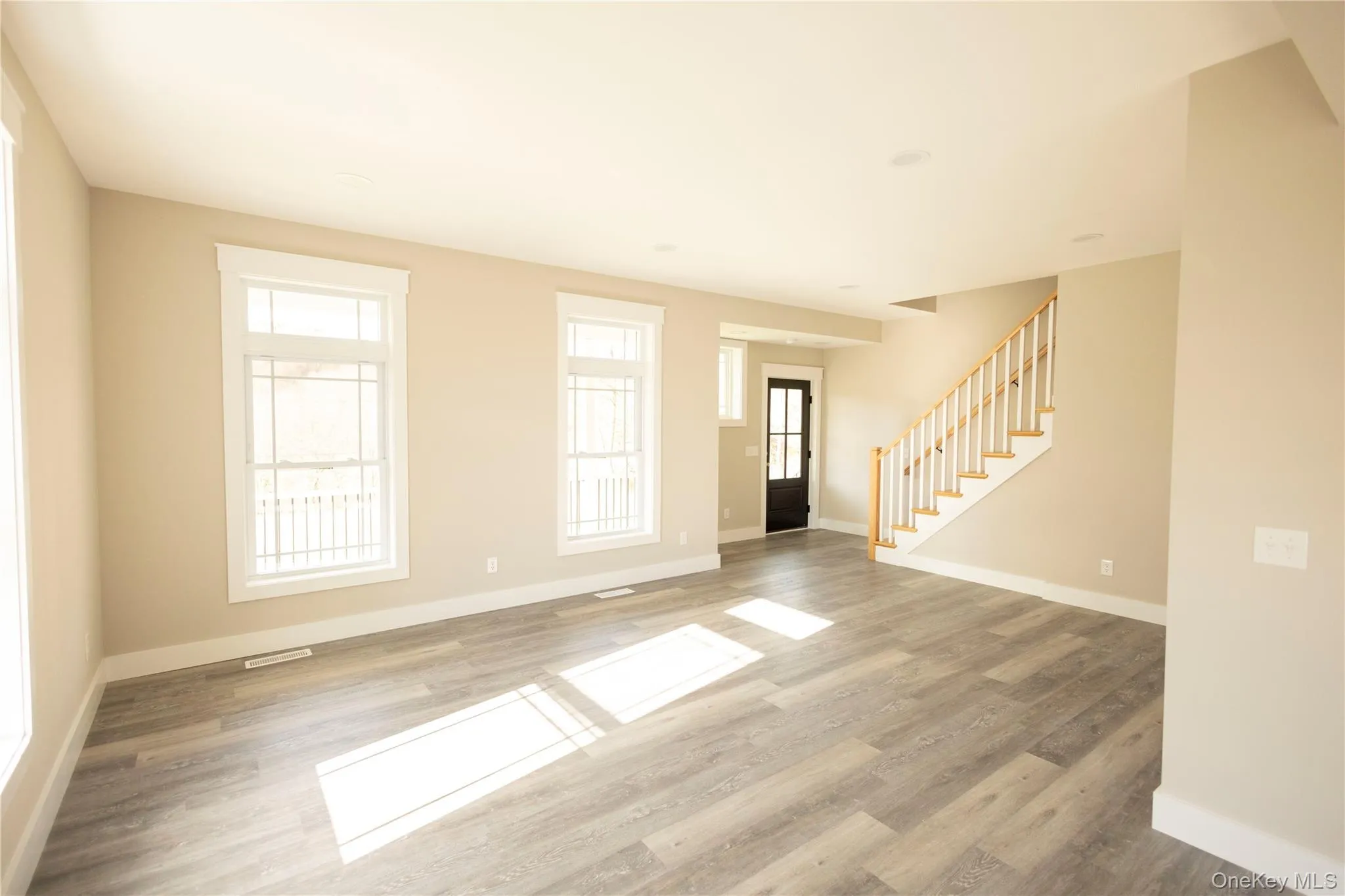 Unfurnished living room with stairway and light wood finished floors Unfurnished living room with stairway and light wood finished floors