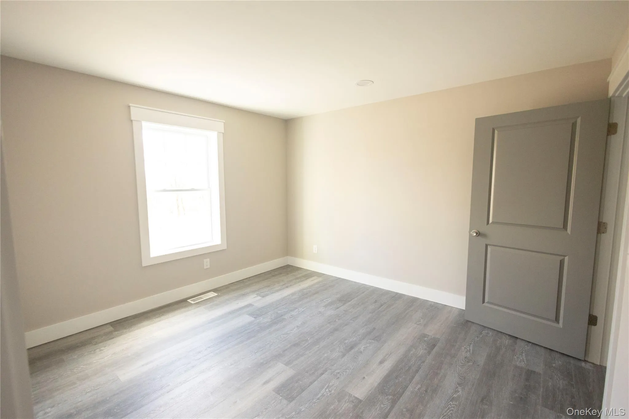 Spare room featuring baseboards and light wood-style floors Spare room featuring baseboards and light wood-style floors
