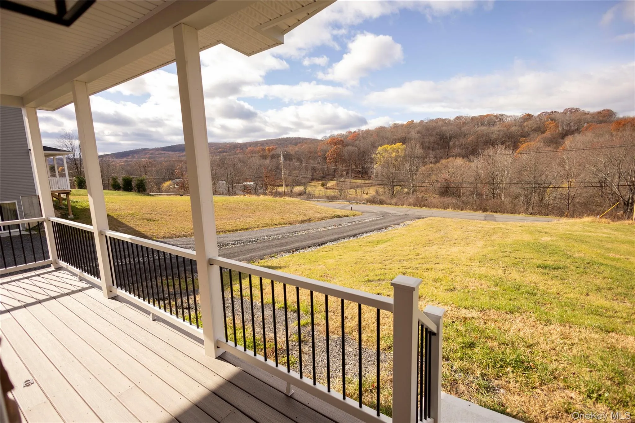 Wooden terrace featuring a lawn and a wooded view Wooden terrace featuring a lawn and a wooded view