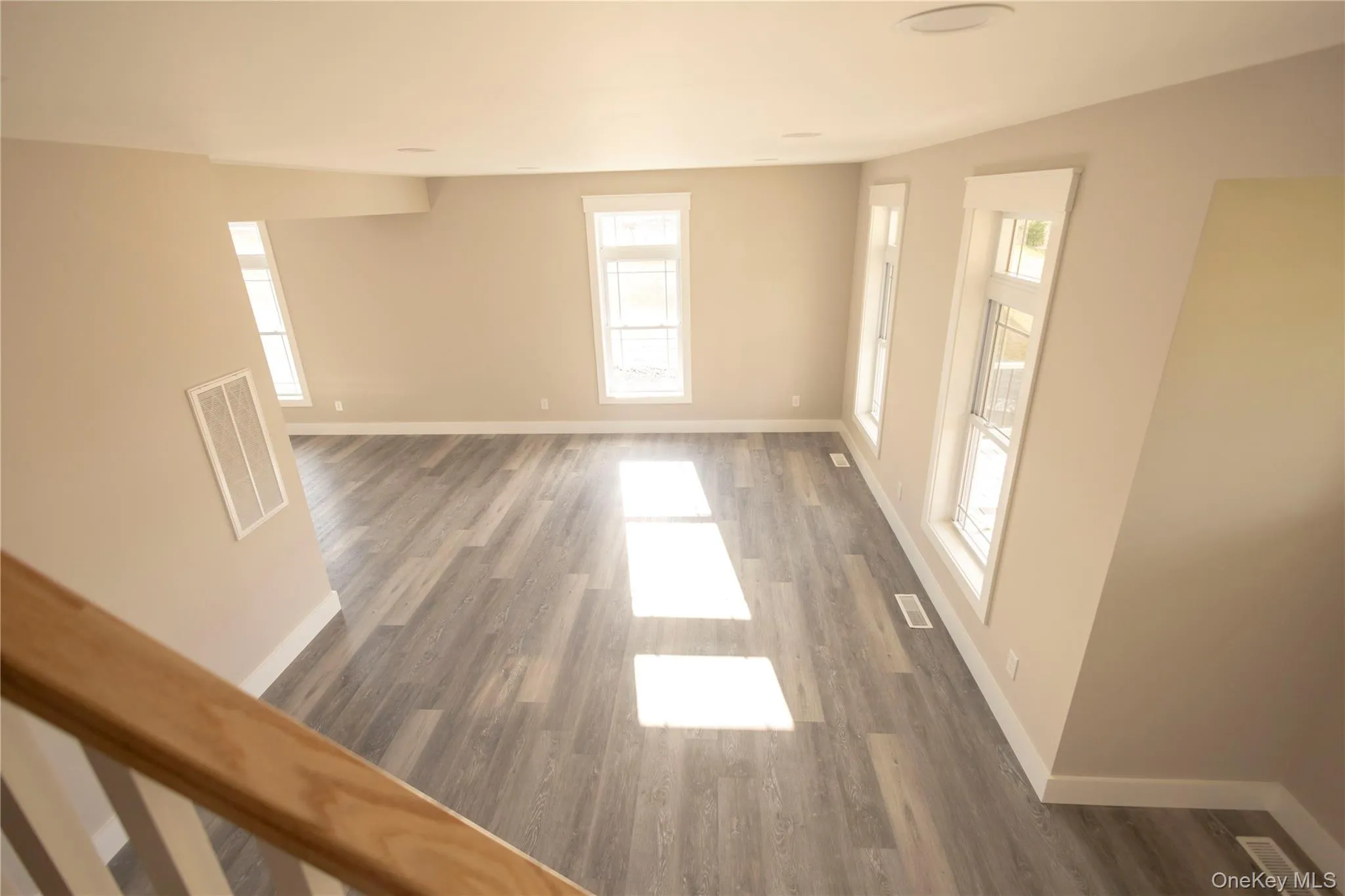 Spare room featuring plenty of natural light and dark wood-style floors Spare room featuring plenty of natural light and dark wood-style floors