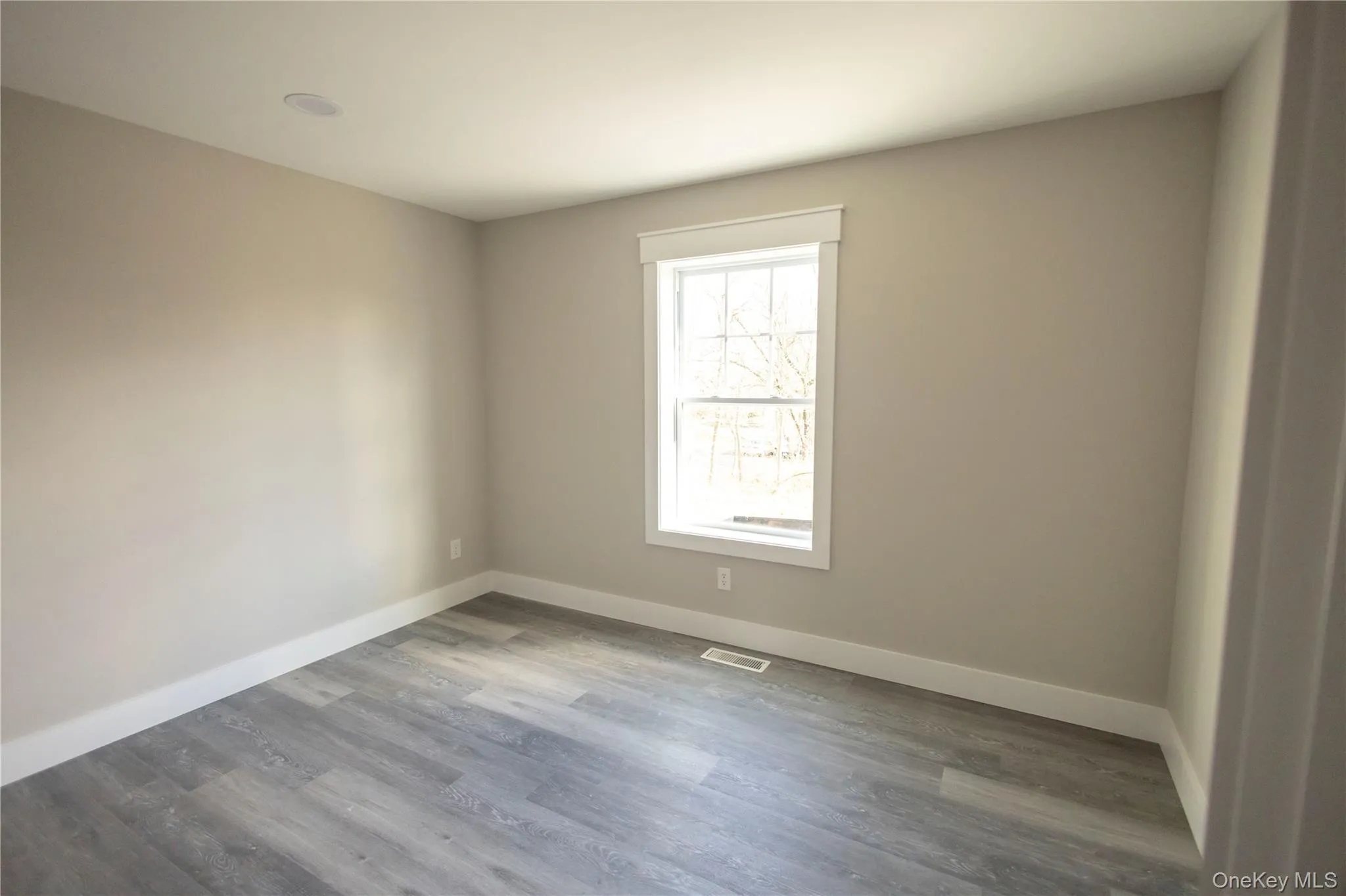 Empty room featuring wood finished floors and baseboards Empty room featuring wood finished floors and baseboards