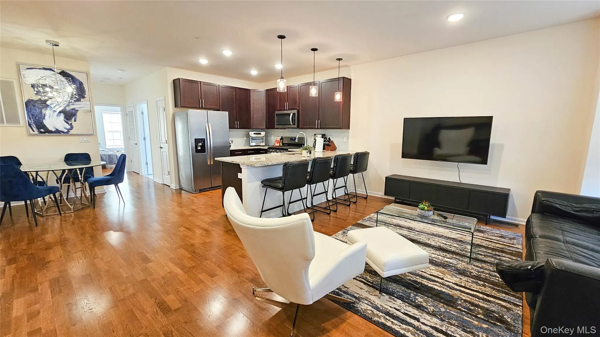 Living room with light wood-style floors, recessed lighting, and a chandelier Living room with light wood-style floors, recessed lighting, and a chandelier