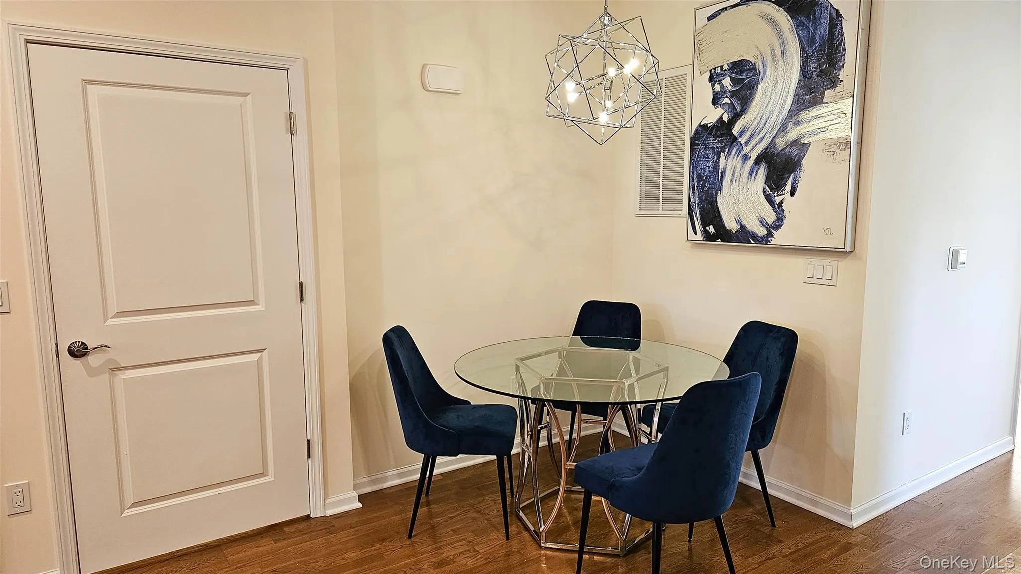 Dining space with dark wood-style flooring and a chandelier Dining space with dark wood-style flooring and a chandelier