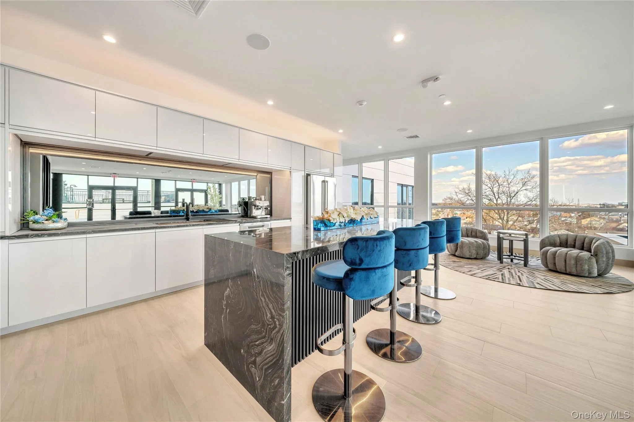 Kitchen with white cabinets, light wood-type flooring, a kitchen island, a kitchen bar, and modern cabinets Kitchen with white cabinets, light wood-type flooring, a kitchen island, a kitchen bar, and modern cabinets