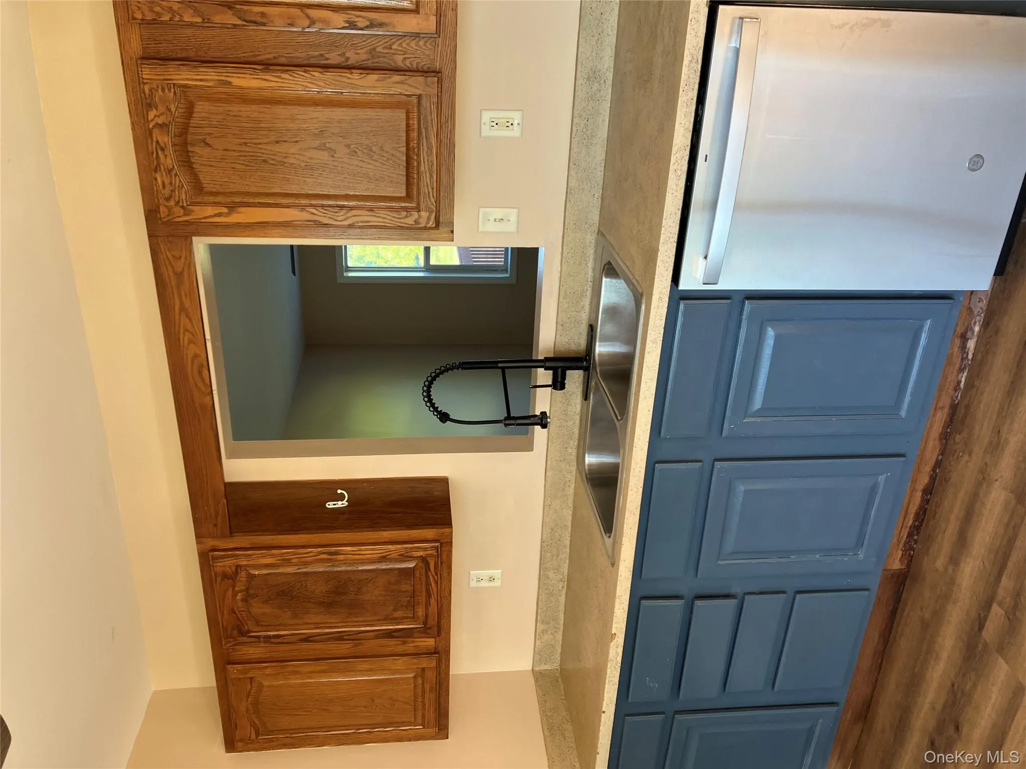 Kitchen with dishwashing machine, light countertops, dark wood-type flooring, and blue cabinets Kitchen with dishwashing machine, light countertops, dark wood-type flooring, and blue cabinets