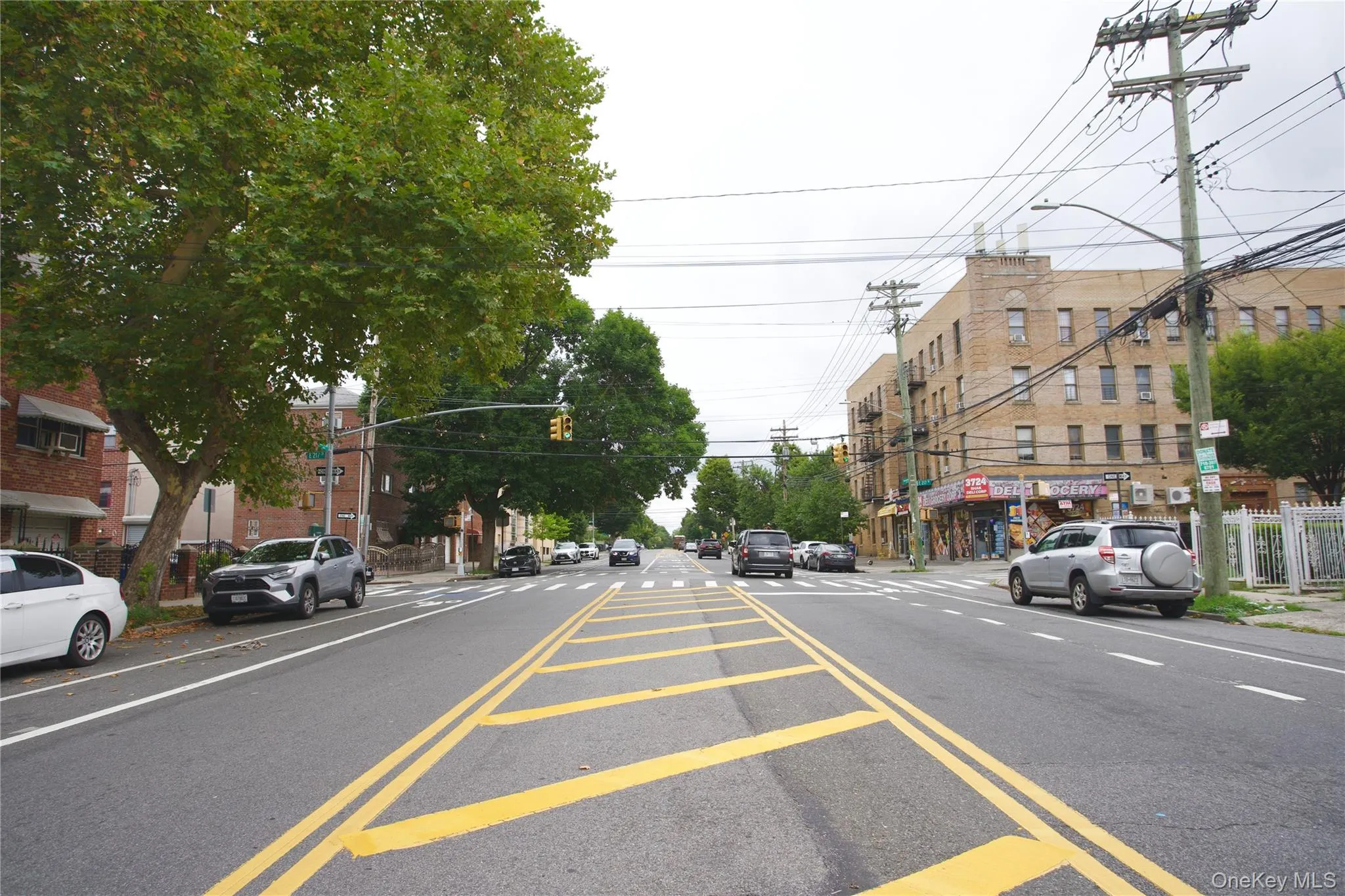 View of asphalt road featuring street lights, sidewalks, and curbs View of asphalt road featuring street lights, sidewalks, and curbs