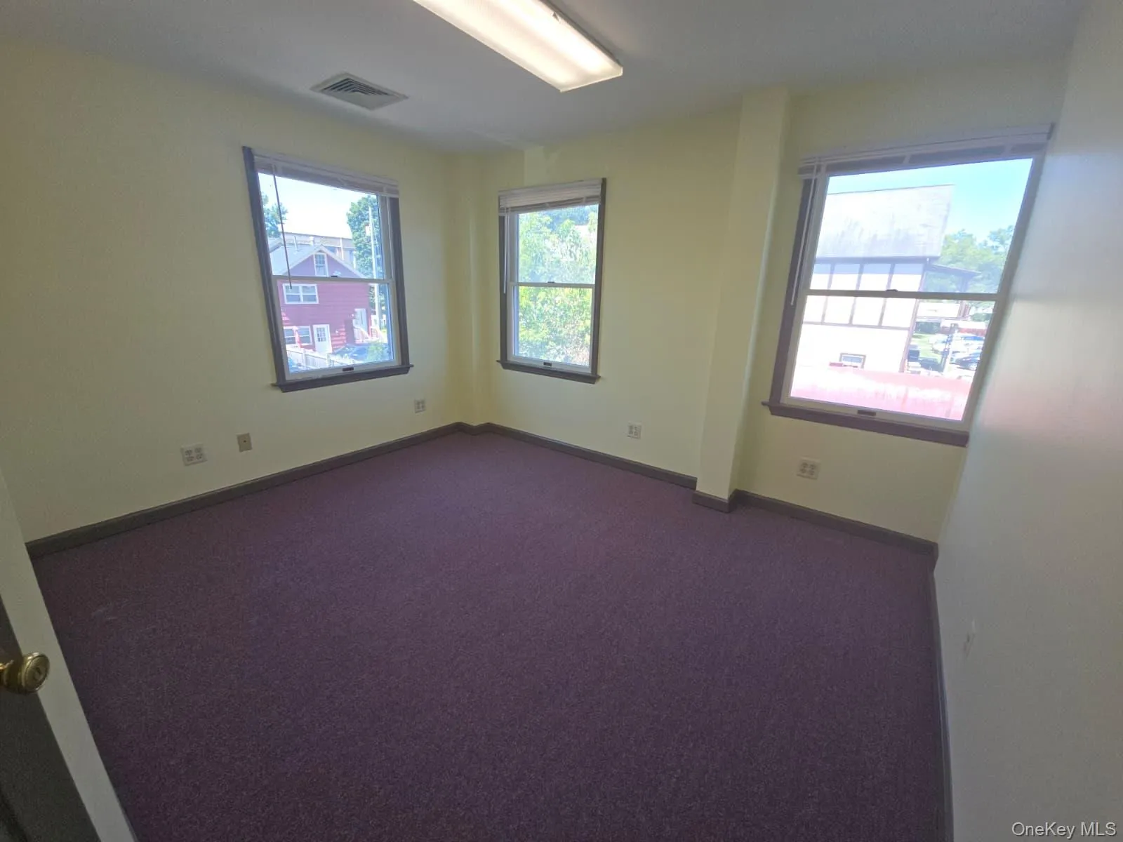 Empty room with dark carpet and baseboards Empty room with dark carpet and baseboards
