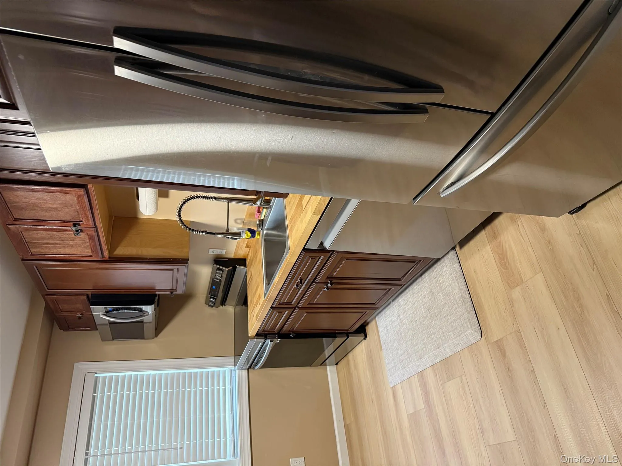 Kitchen featuring appliances with stainless steel finishes, light countertops, and light wood-type flooring Kitchen featuring appliances with stainless steel finishes, light countertops, and light wood-type flooring