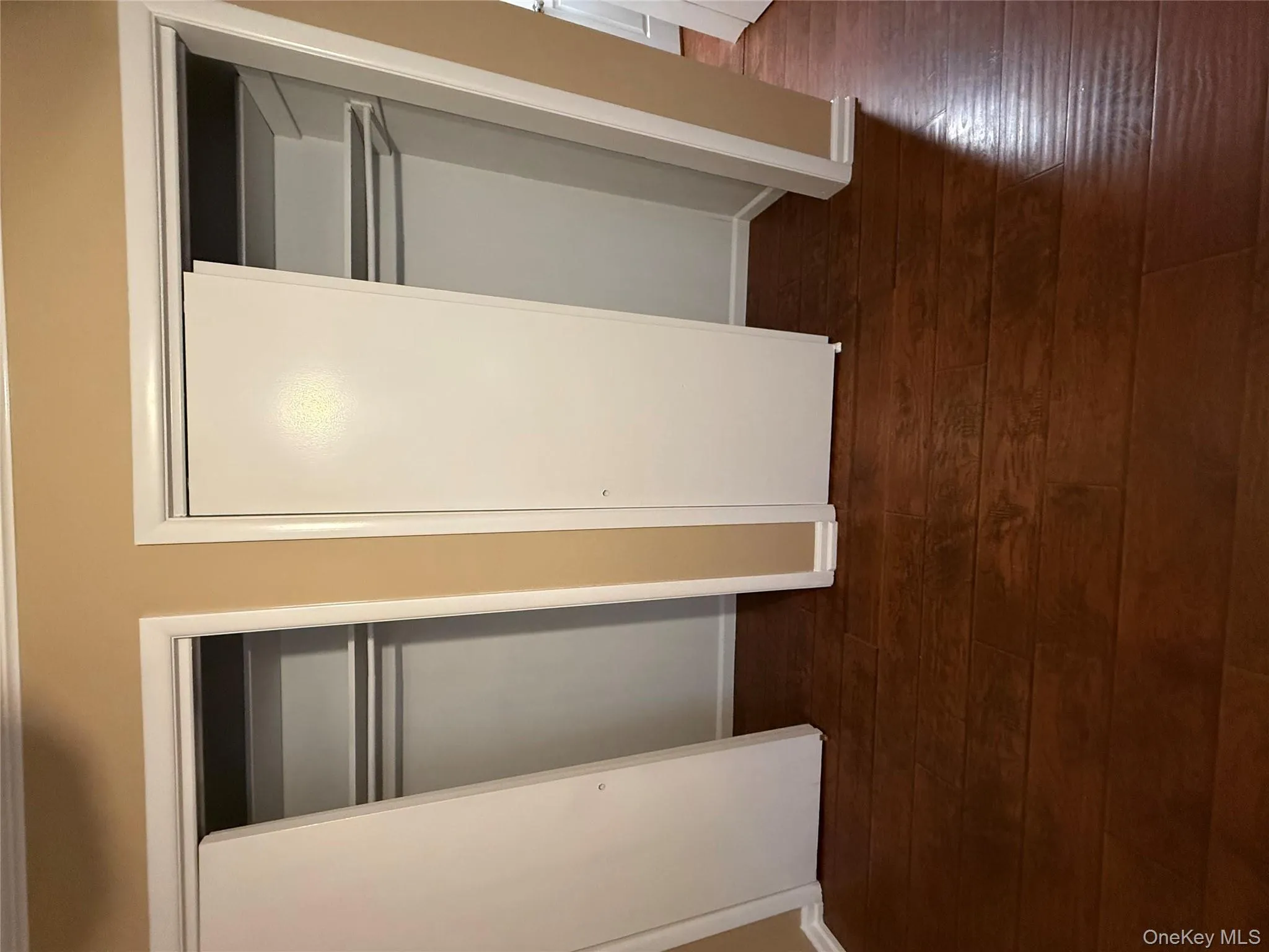 Unfurnished bedroom featuring two closets and dark wood-style floors Unfurnished bedroom featuring two closets and dark wood-style floors