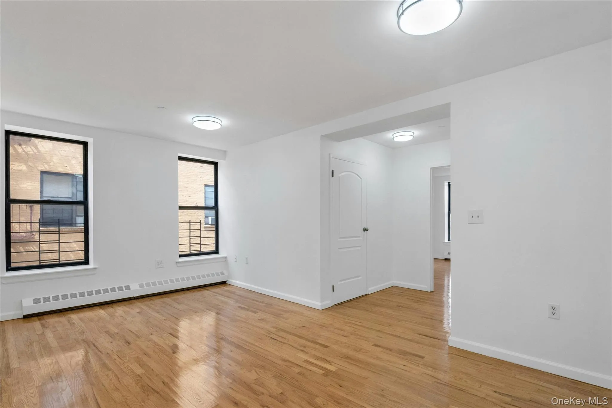 Empty room featuring baseboard heating and light wood-type flooring Empty room featuring baseboard heating and light wood-type flooring