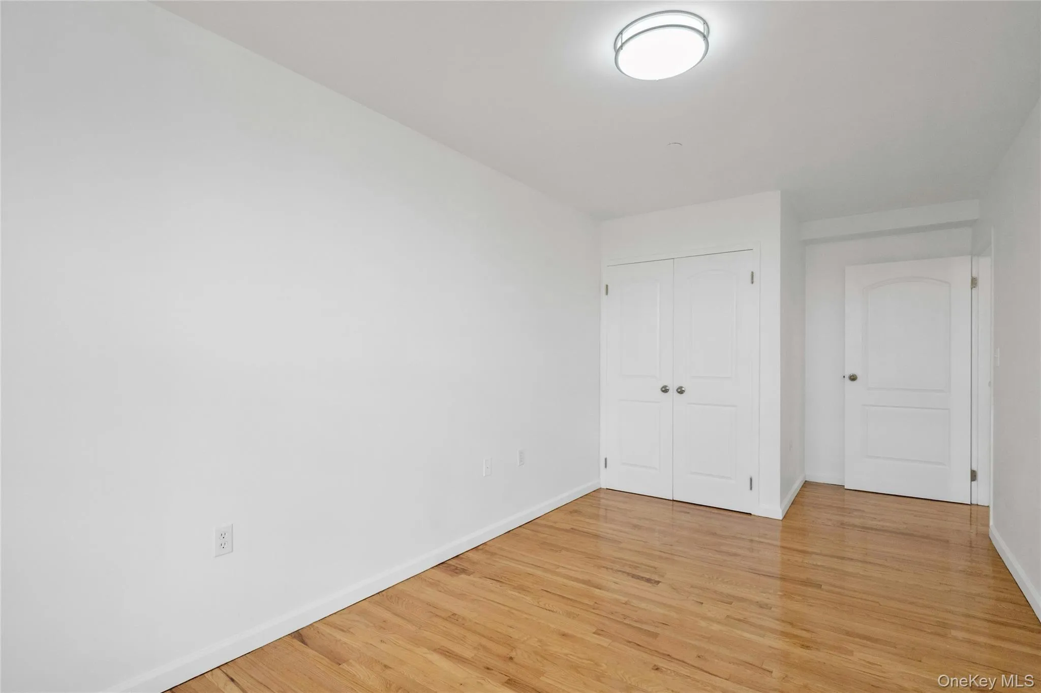 Unfurnished bedroom featuring light wood-style flooring and a closet Unfurnished bedroom featuring light wood-style flooring and a closet