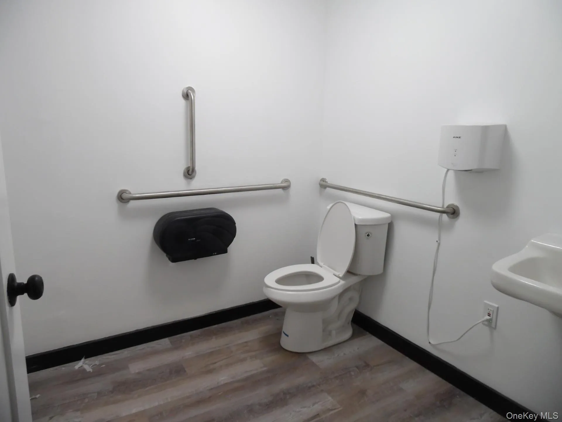 ADA Bathroom with light wood-style flooring and toilet ADA Bathroom with light wood-style flooring and toilet