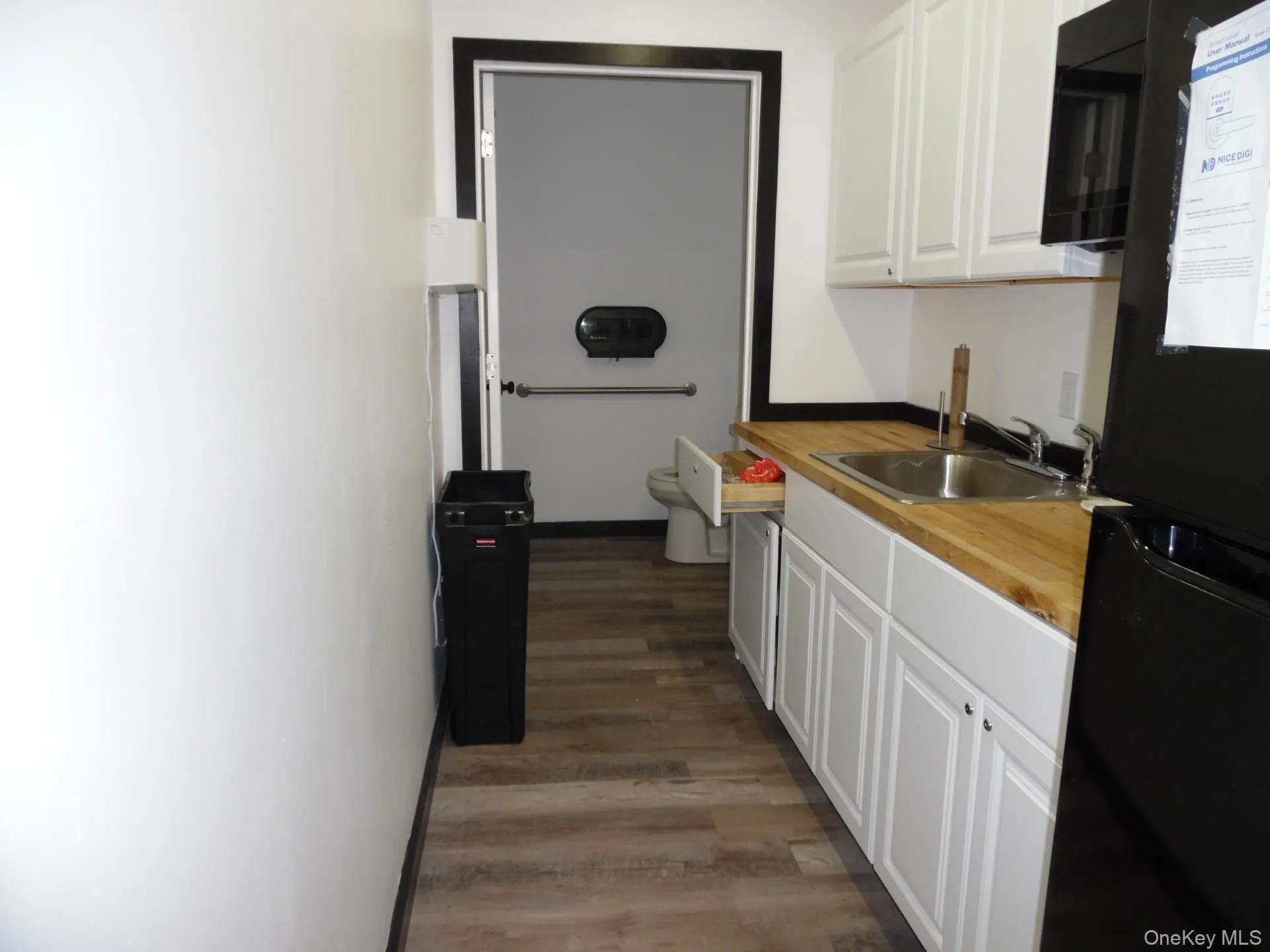 Kitchen with white cabinets, black appliances, and dark wood-style flooring Kitchen with white cabinets, black appliances, and dark wood-style flooring