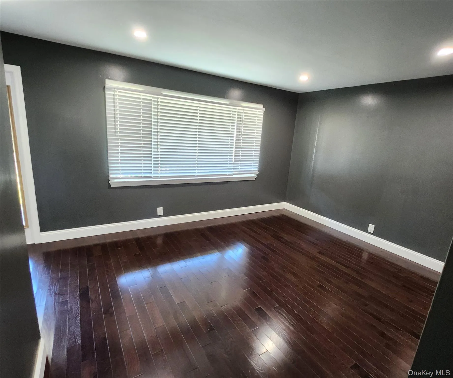 Unfurnished room with dark wood finished floors and recessed lighting Unfurnished room with dark wood finished floors and recessed lighting