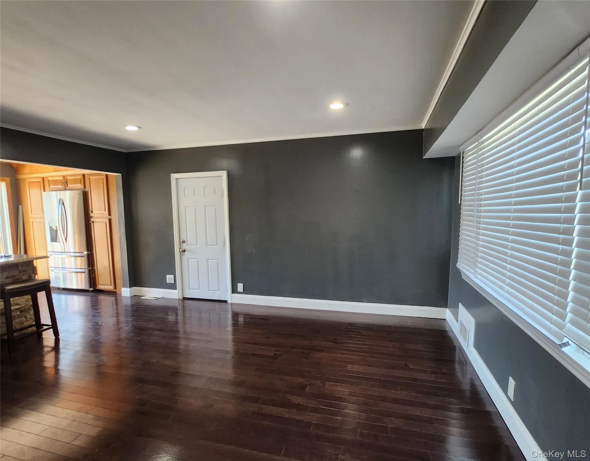 Unfurnished room with dark wood-style floors, recessed lighting, and crown molding Unfurnished room with dark wood-style floors, recessed lighting, and crown molding