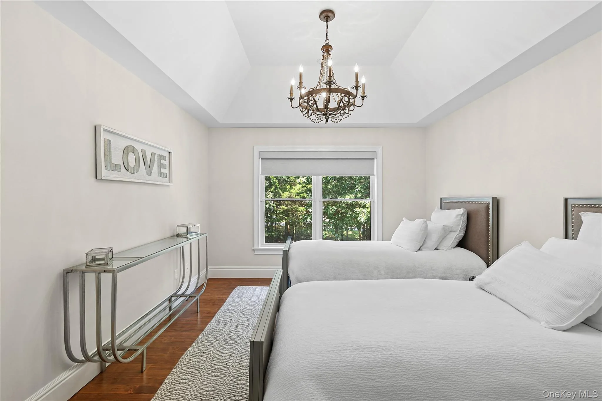 Bedroom featuring wood finished floors and a chandelier Bedroom featuring wood finished floors and a chandelier